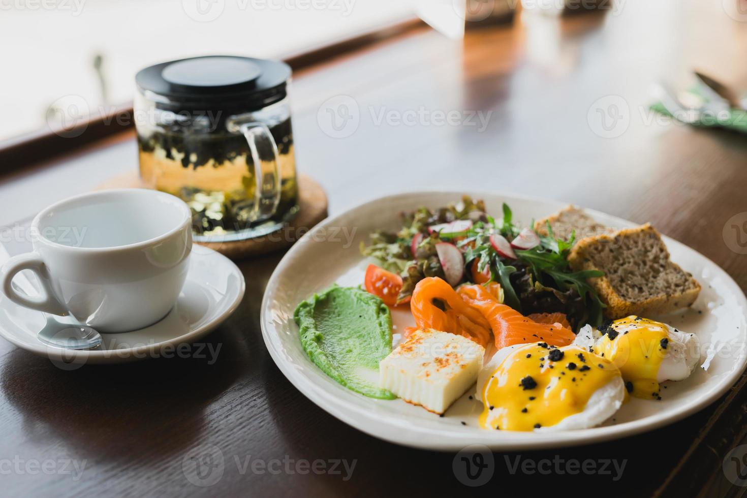 Light and hearty breakfast, brunch with scrambled eggs, toast on grain bread and smoked salmon and guacamole. Served with a mix of arugula and radish photo
