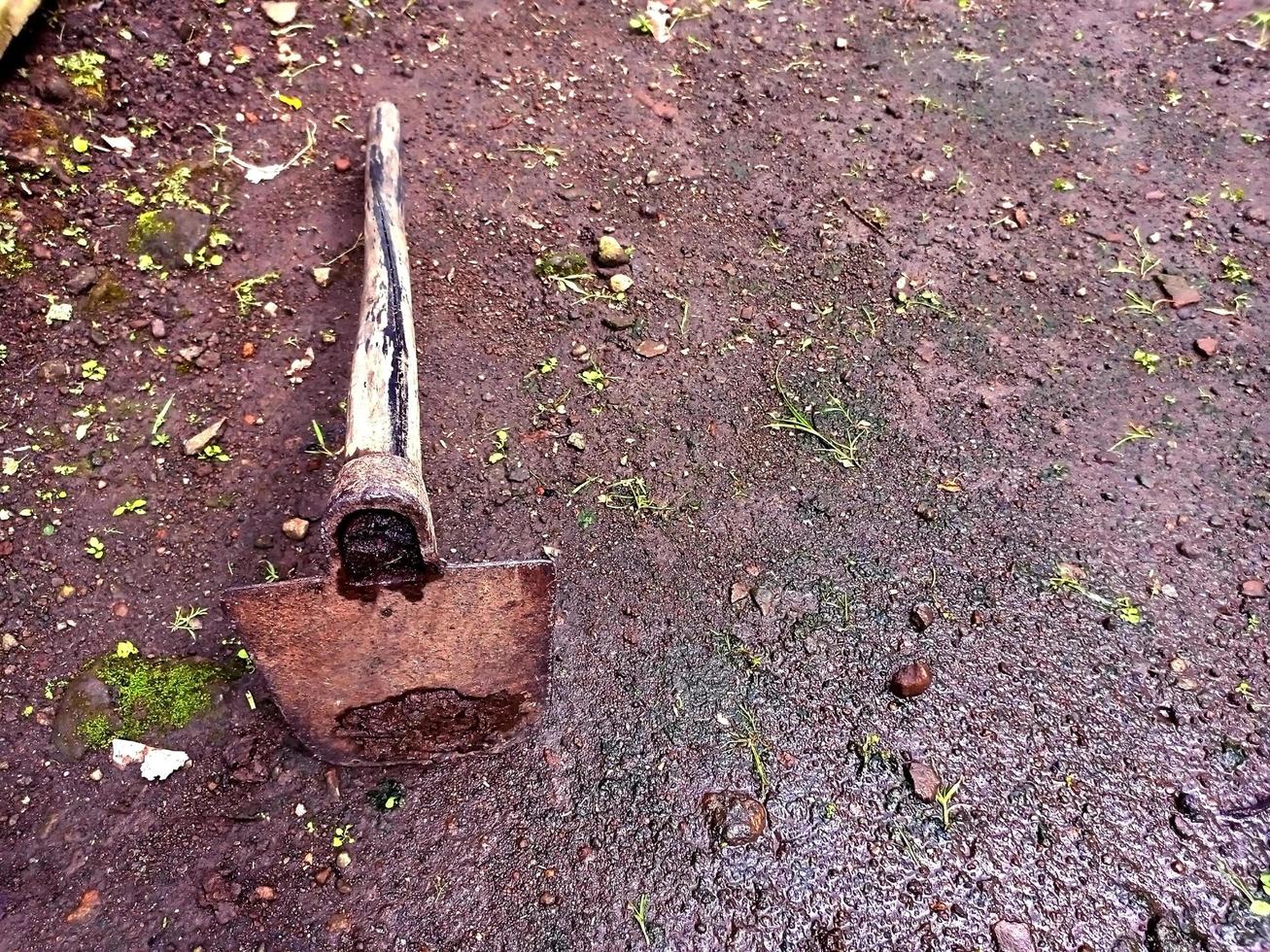 Farmer's old hoe lying on the ground photo