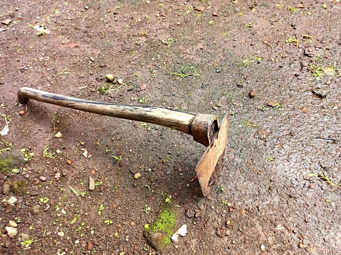 Farmer's old hoe lying on the ground photo