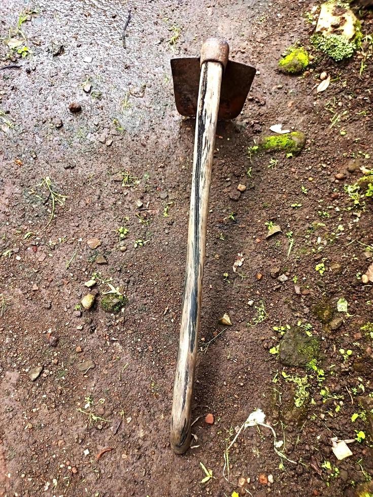 Farmer's old hoe lying on the ground photo