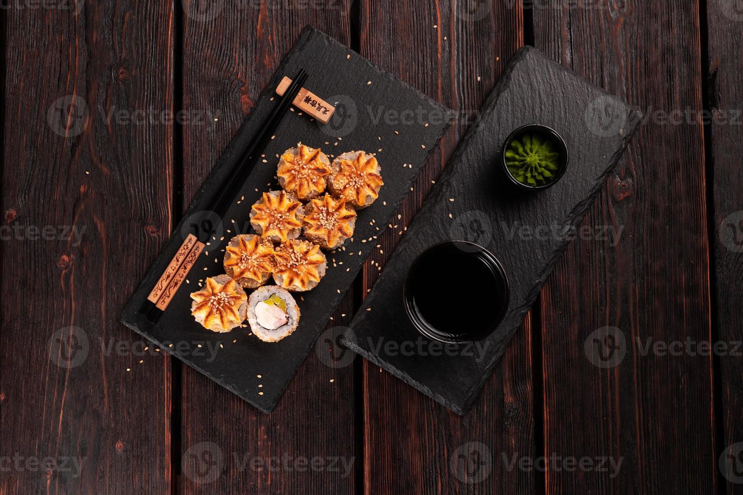 Sushi roll philadelphia with crab avocado and cream cheese on black background top view. Sushi menu. Japanese food concept photo