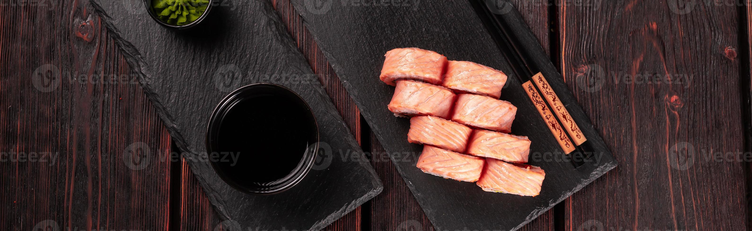 Banner Roll with fish sushi and chopsticks top view copy space - asian food concept photo