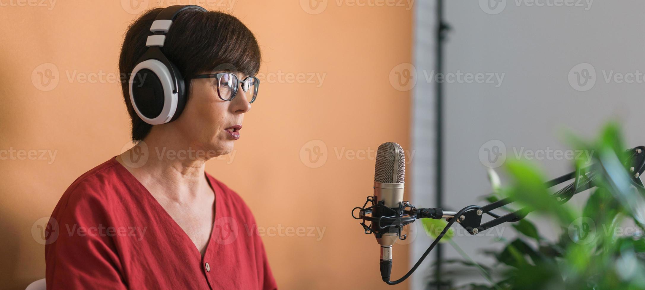 Banner middle-aged woman radio host making podcast recording for online show - broadcast and dj concept photo