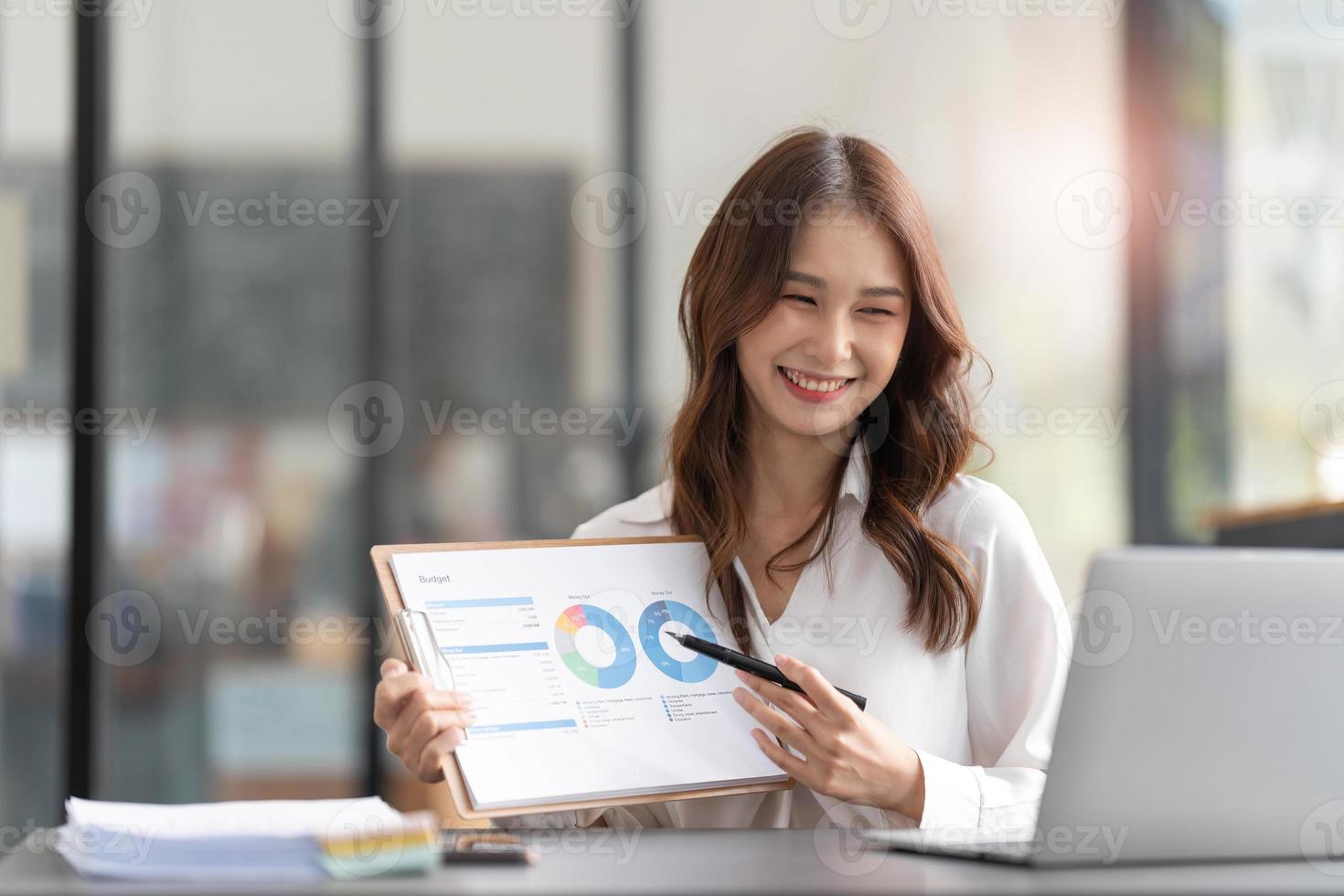 Businesswoman presenting charts and graphs on video call online. Asian Business woman having conference call with client on laptop. Closeup business woman working laptop computer indoor. photo