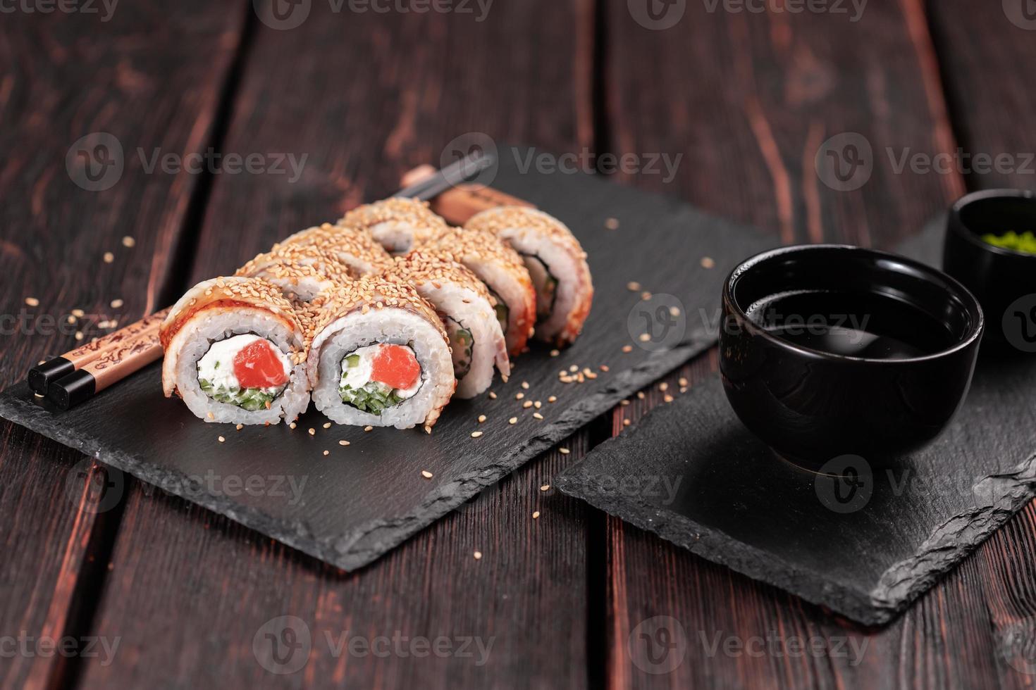 rollo de sushi con anguila ahumada y salmón con pepino y queso. delicioso juego de rollos de sushi fresco tradicional. menú de sushi restaurante de cocina japonesa. comida asiática foto