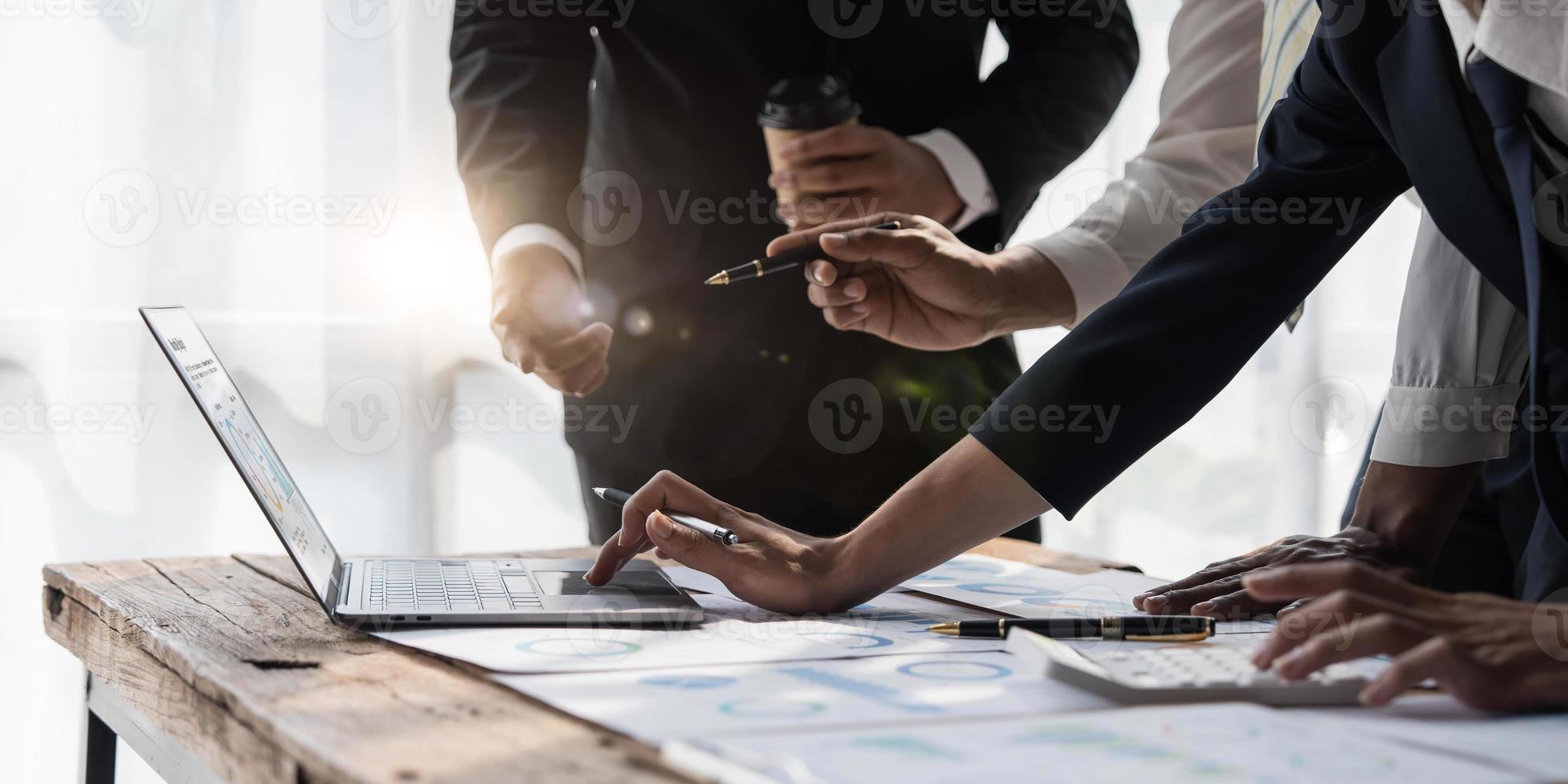 gente de negocios reunida usando computadora portátil, calculadora, cuaderno, papel gráfico del mercado de valores para planes de análisis para mejorar la calidad el próximo mes. conferencia discusión concepto corporativo foto