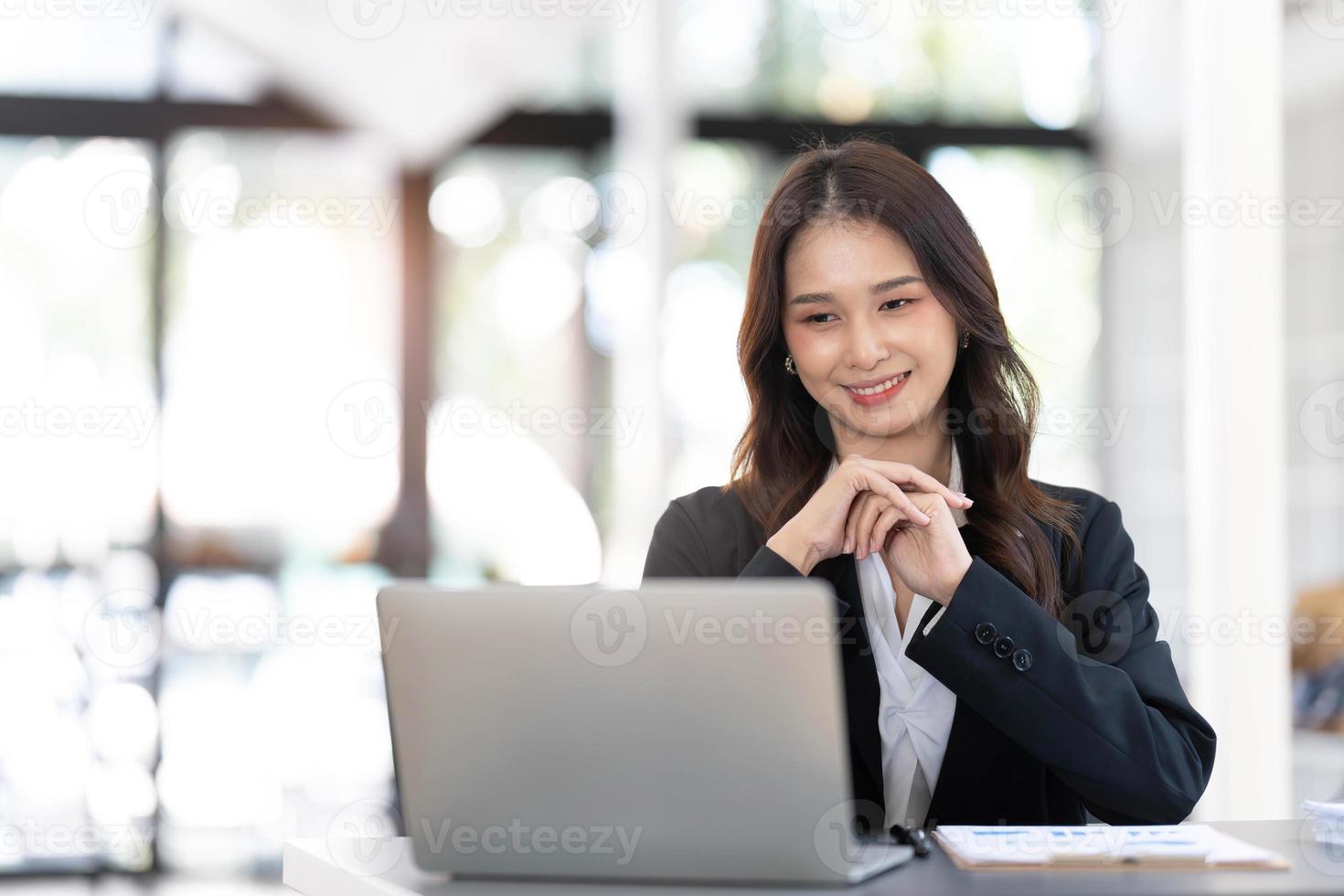 Asian Business woman using calculator and laptop for doing math finance on an office desk, tax, report, accounting, statistics, and analytical research concept photo