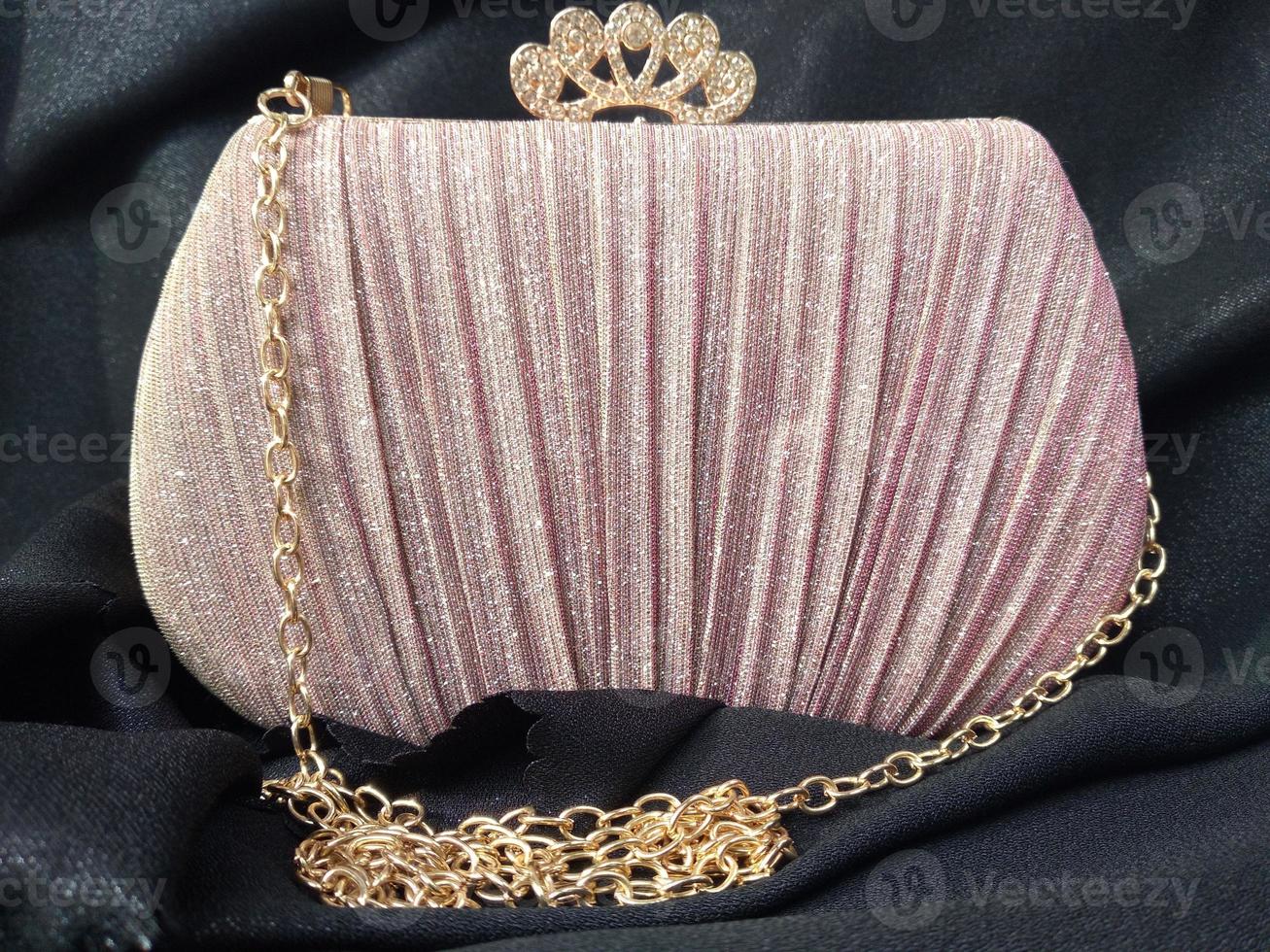 The shining pink bag looks elegant with a golden colored chain strap suitable for going to parties or invitations photo
