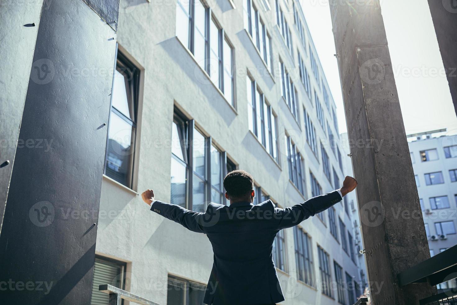 Successful african american businessman with arms up celebrating victory. photo