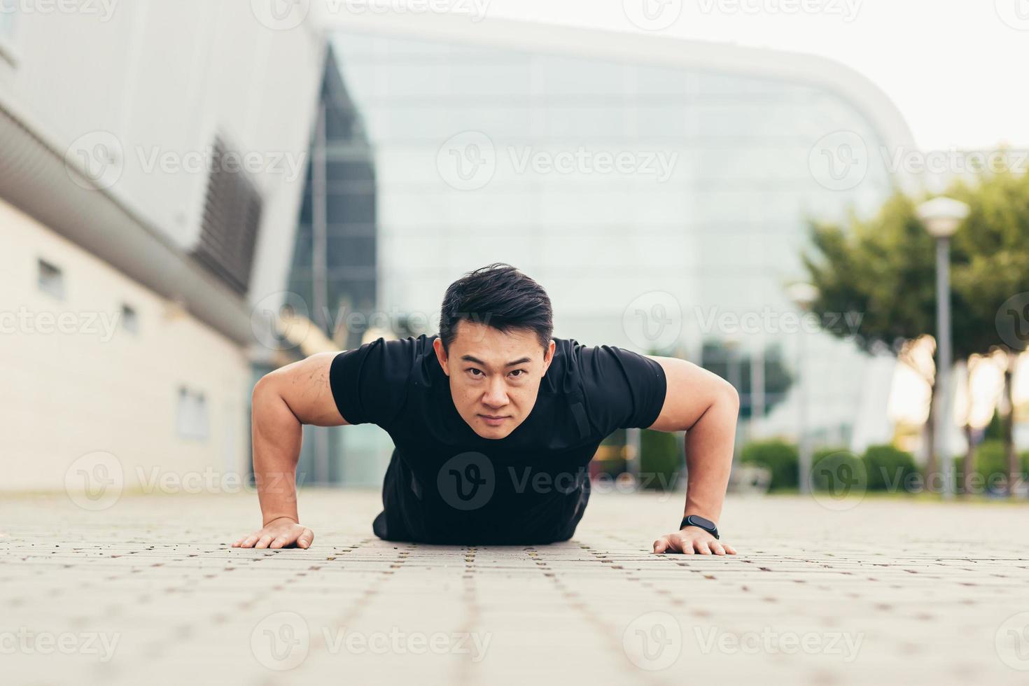 Male asian athlete doing fitness in the morning near the stadium pushes off the ground rejoices photo