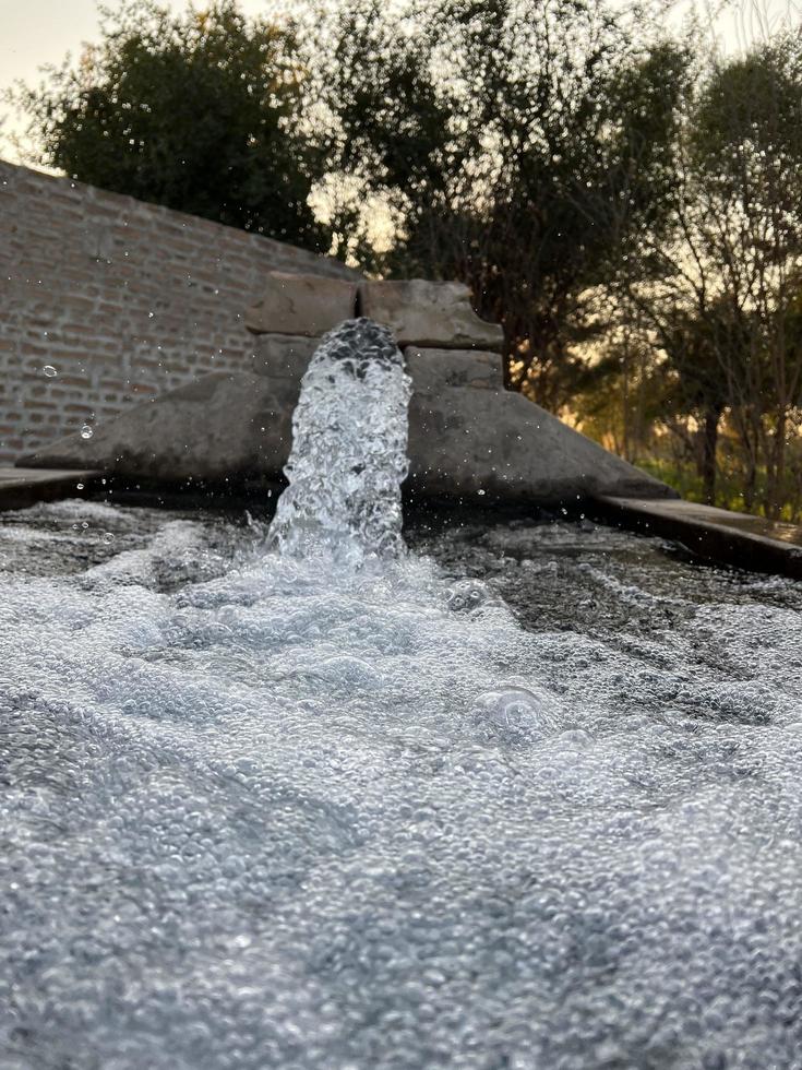 flujo de agua de riego desde la tubería hasta el canal para campos agrícolas foto