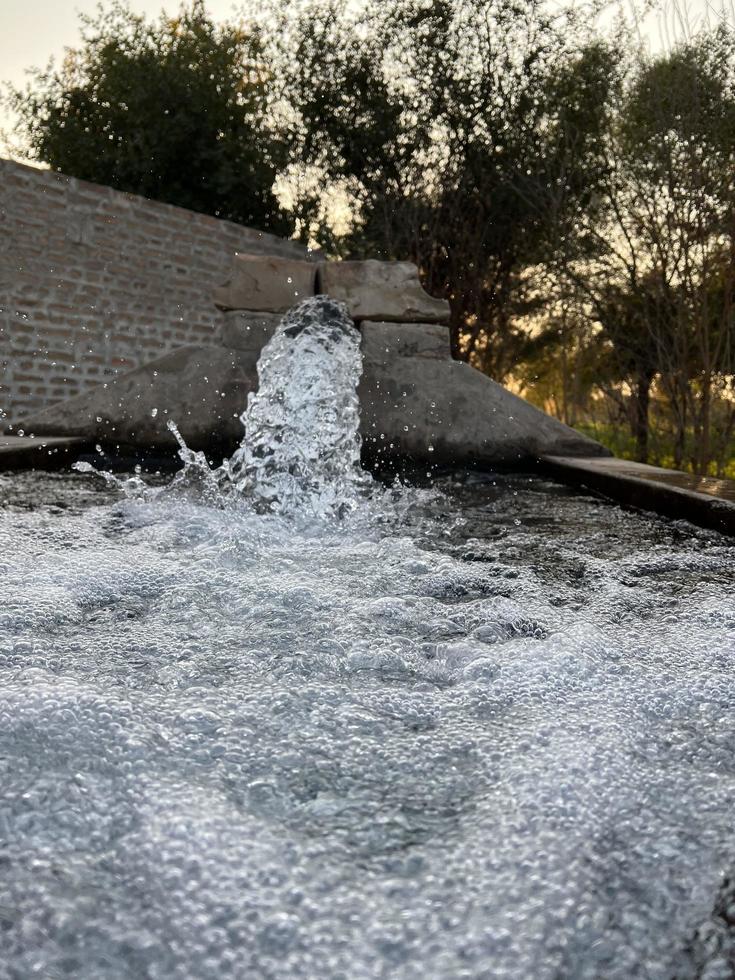 Irrigation water flow from pipe to canal for agriculture fields photo