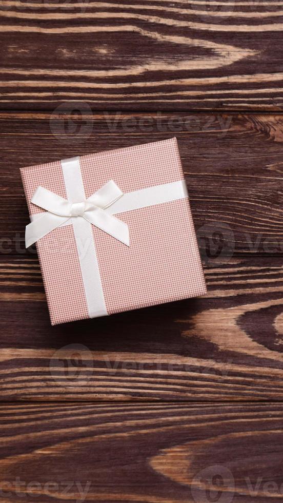 Present box on wooden background, copy space photo