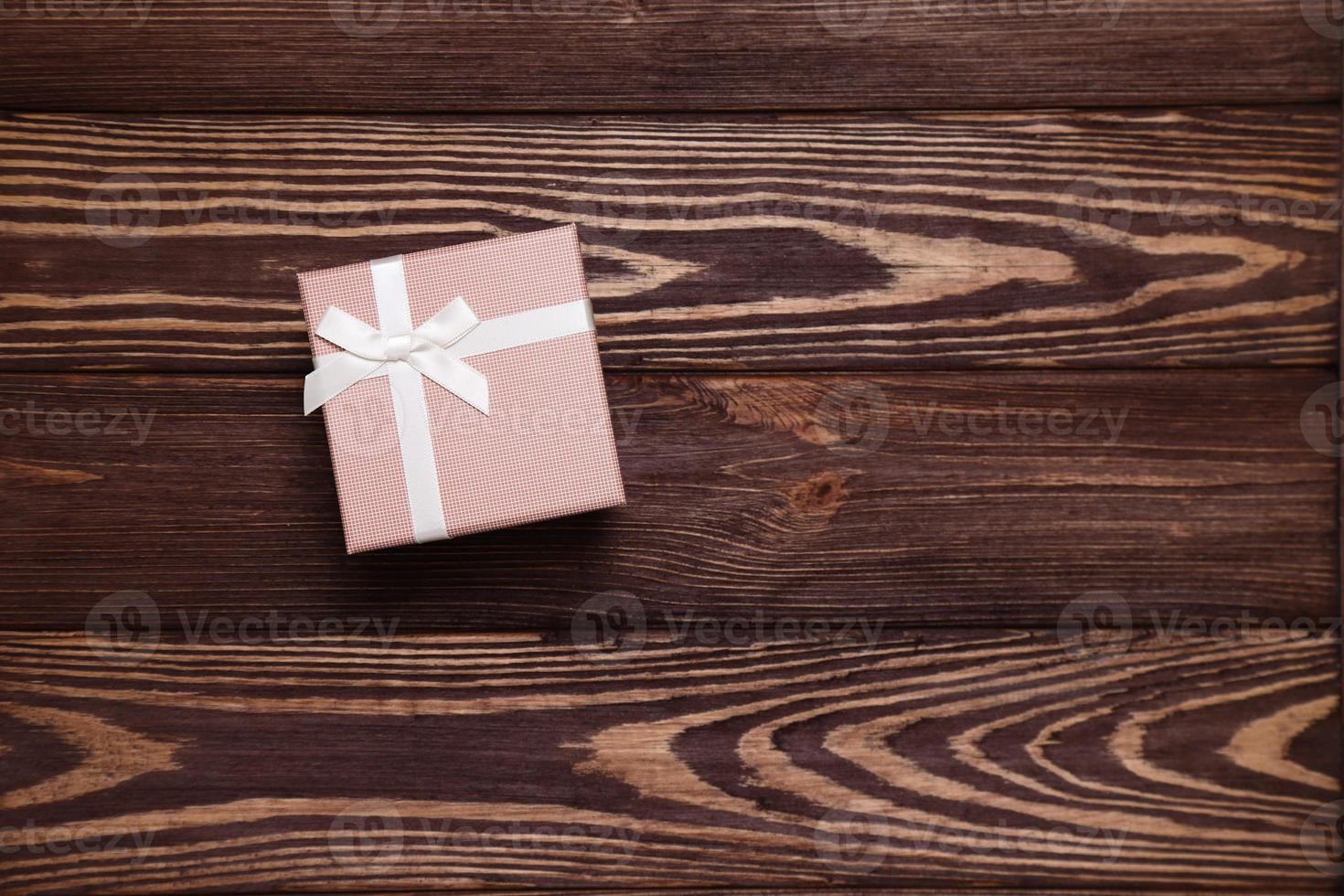 Present box on wooden background, copy space photo