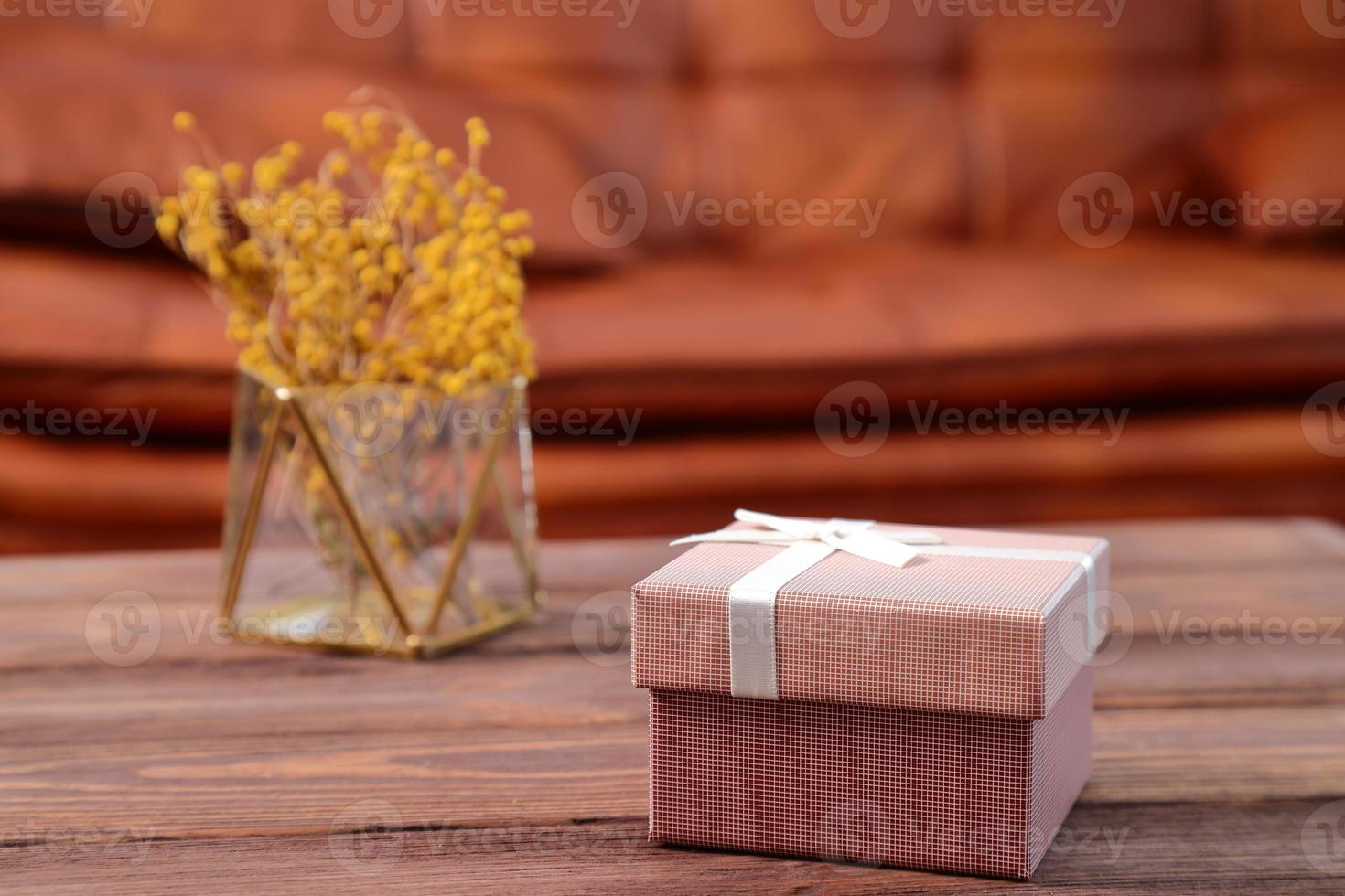 Present box on wooden table in living room photo