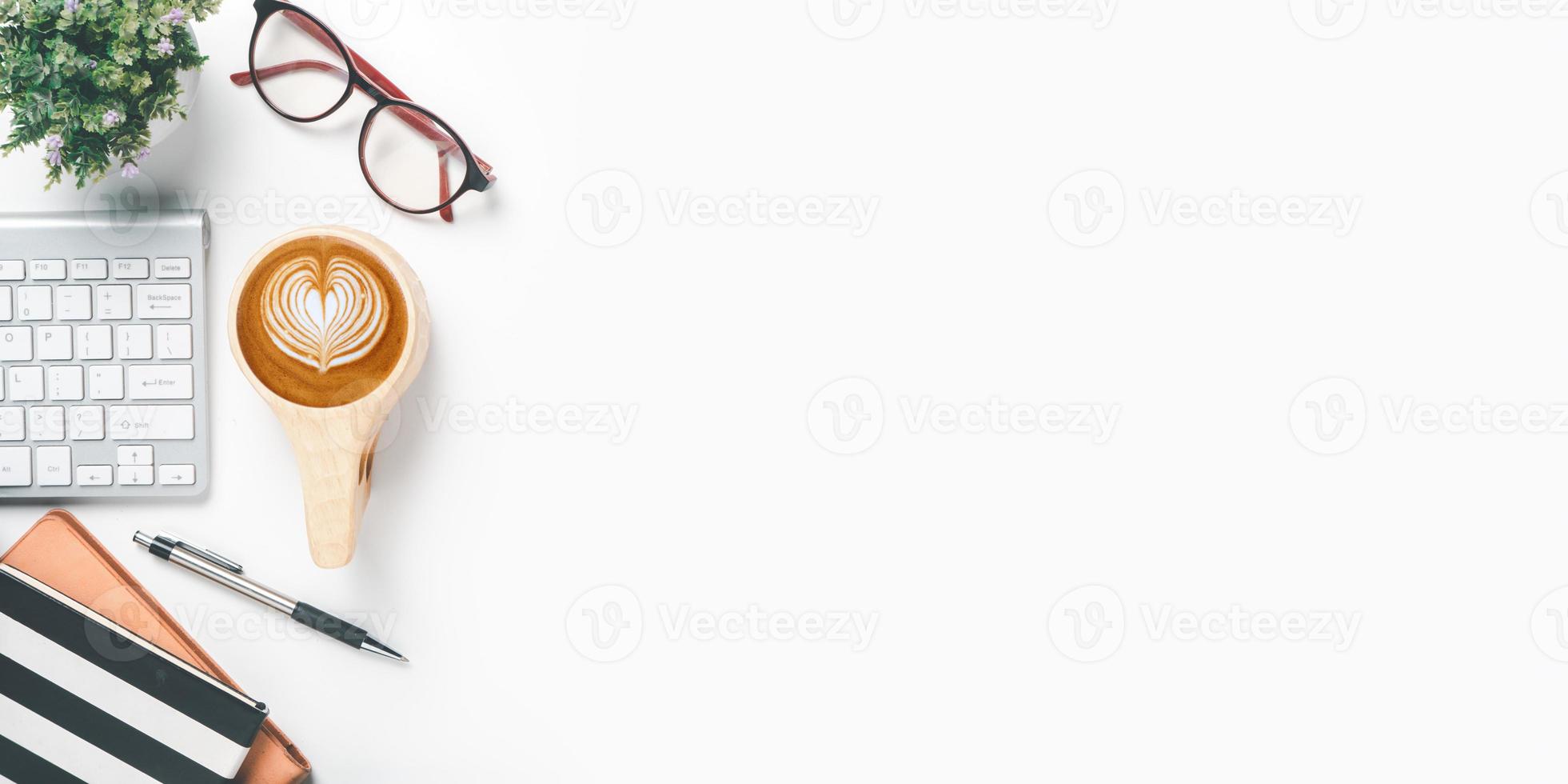 Office desk with keyboard computer, Pen, notebook, Cup of coffee on yellow background, Top view with copy space, Mock up. photo