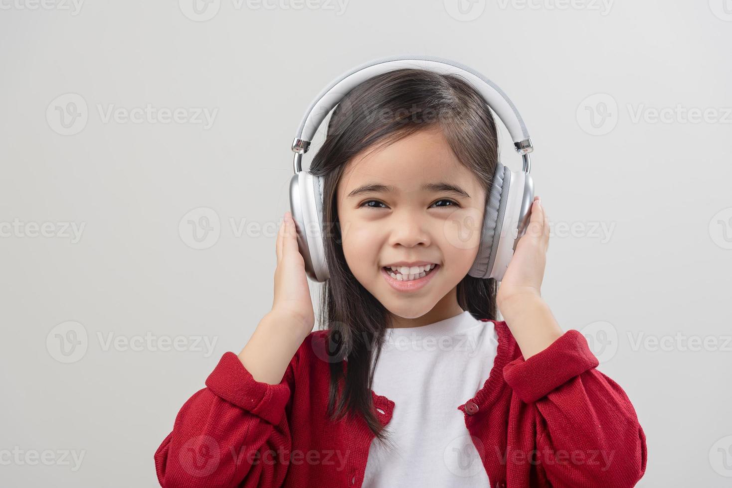 Lttle girl Asia cute enjoying her music headphones photo