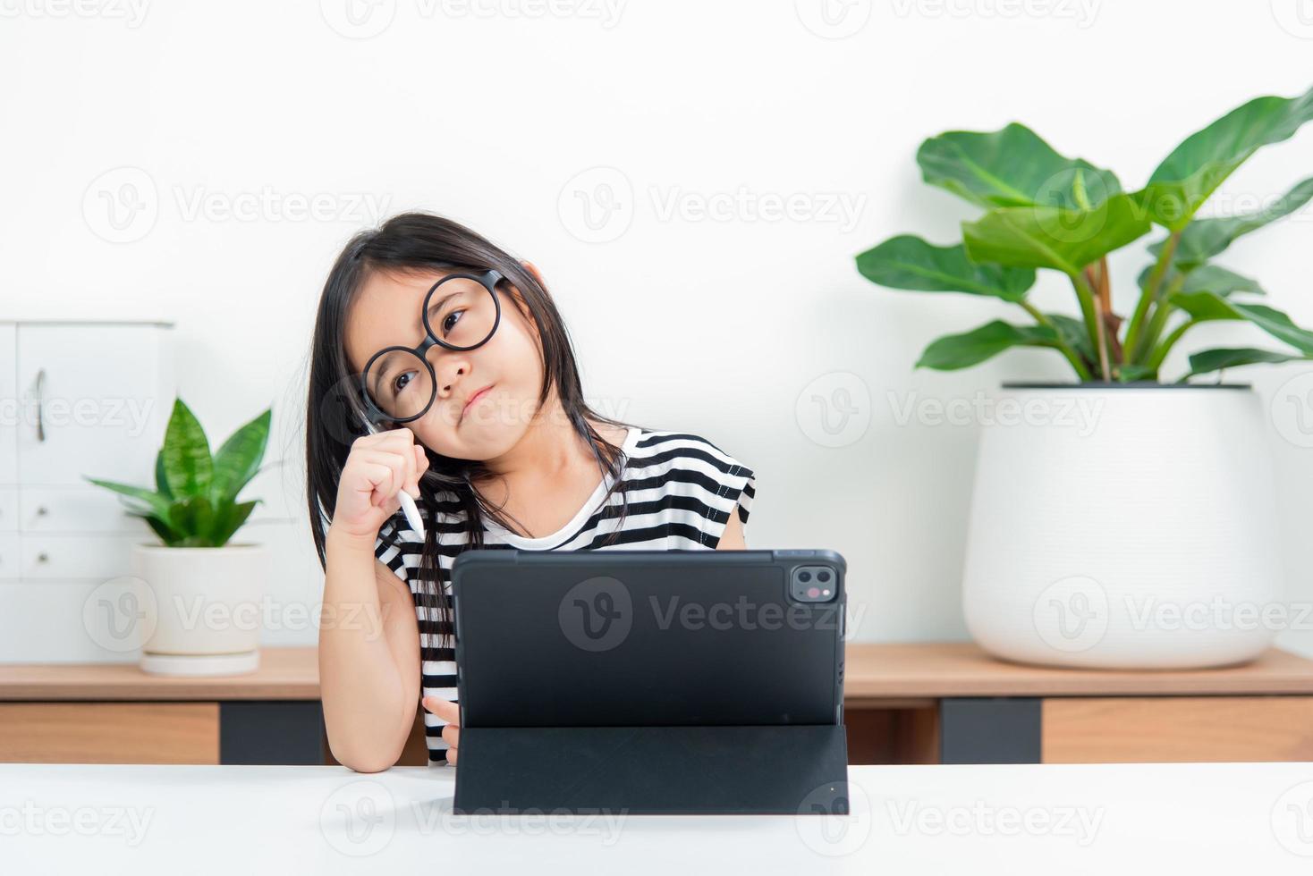 Asian child girl student wow excited on video call learning to studying online class or person learn from home school with tablet photo
