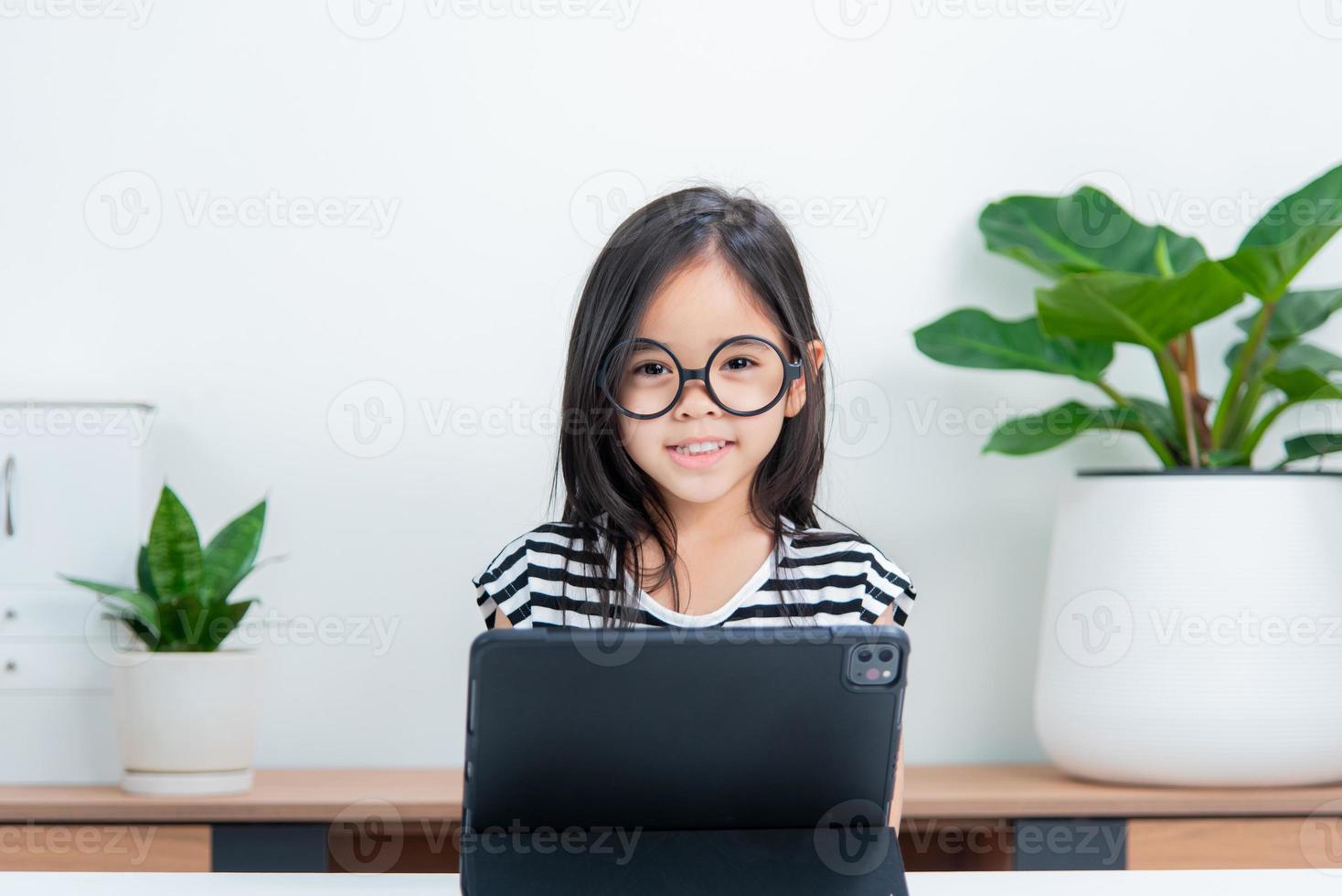 Asian child girl student wow excited on video call learning to studying online class or person learn from home school with tablet photo