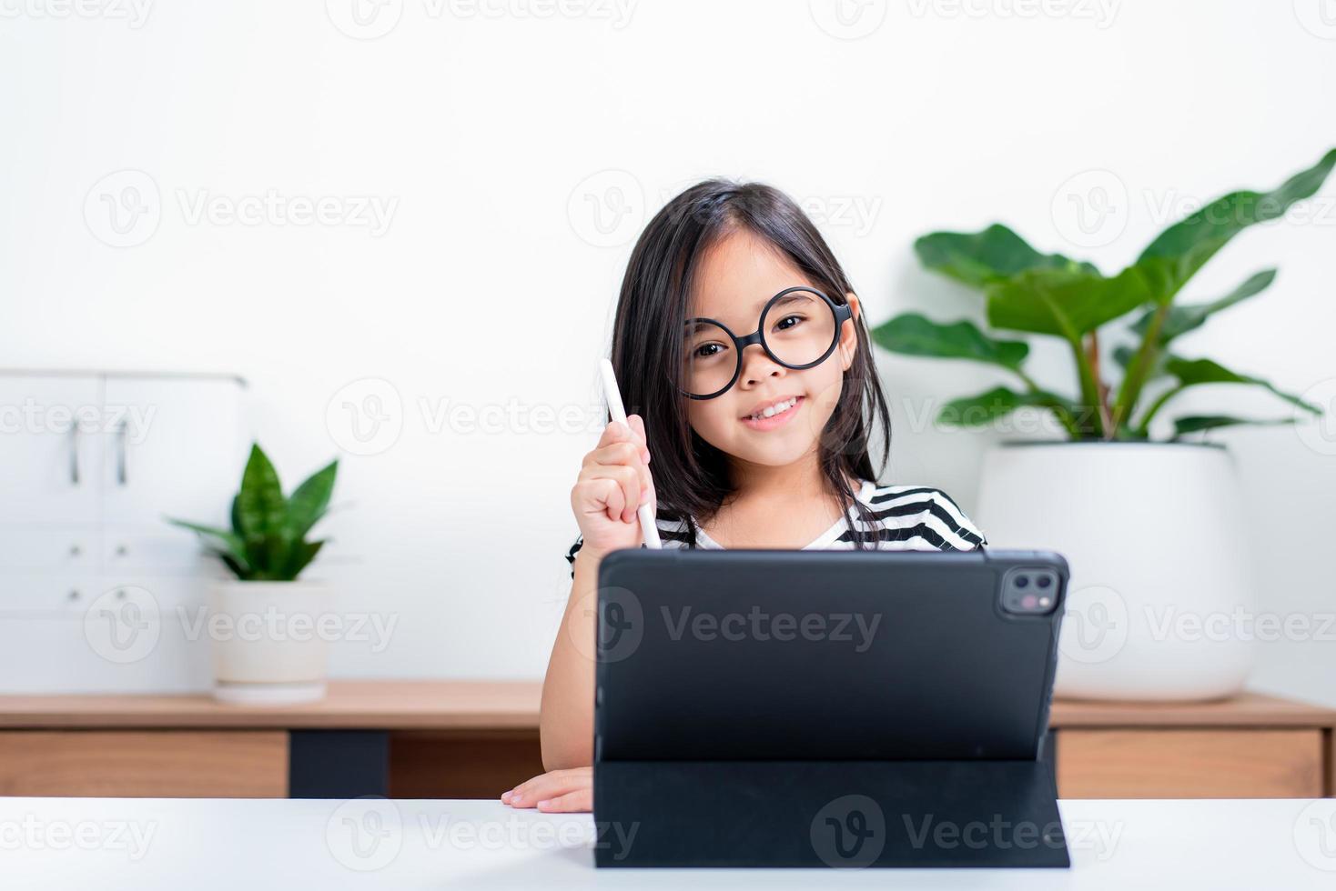 Asian child girl student wow excited on video call learning to studying online class or person learn from home school with tablet photo