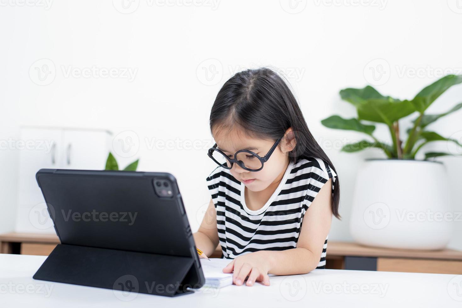 Asian child girl student wow excited on video call learning to studying online class or person learn from home school with tablet photo