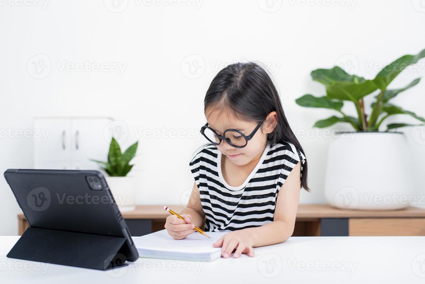 Asian child girl student wow excited on video call learning to studying online class or person learn from home school with tablet photo