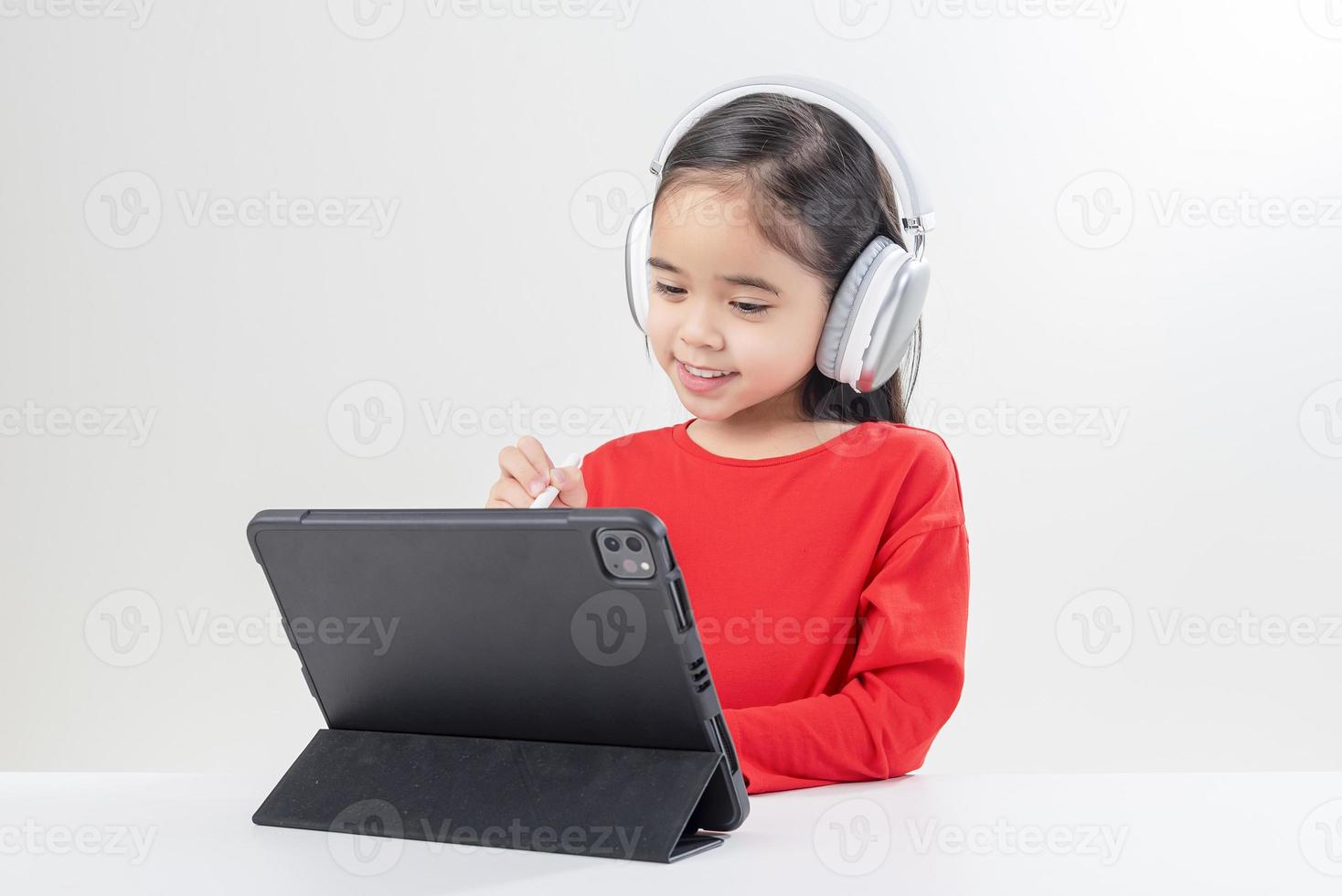 little girl asia cute put on headphones have video call distant class with teacher using laptop,  study online on computer, homeschooling concept photo