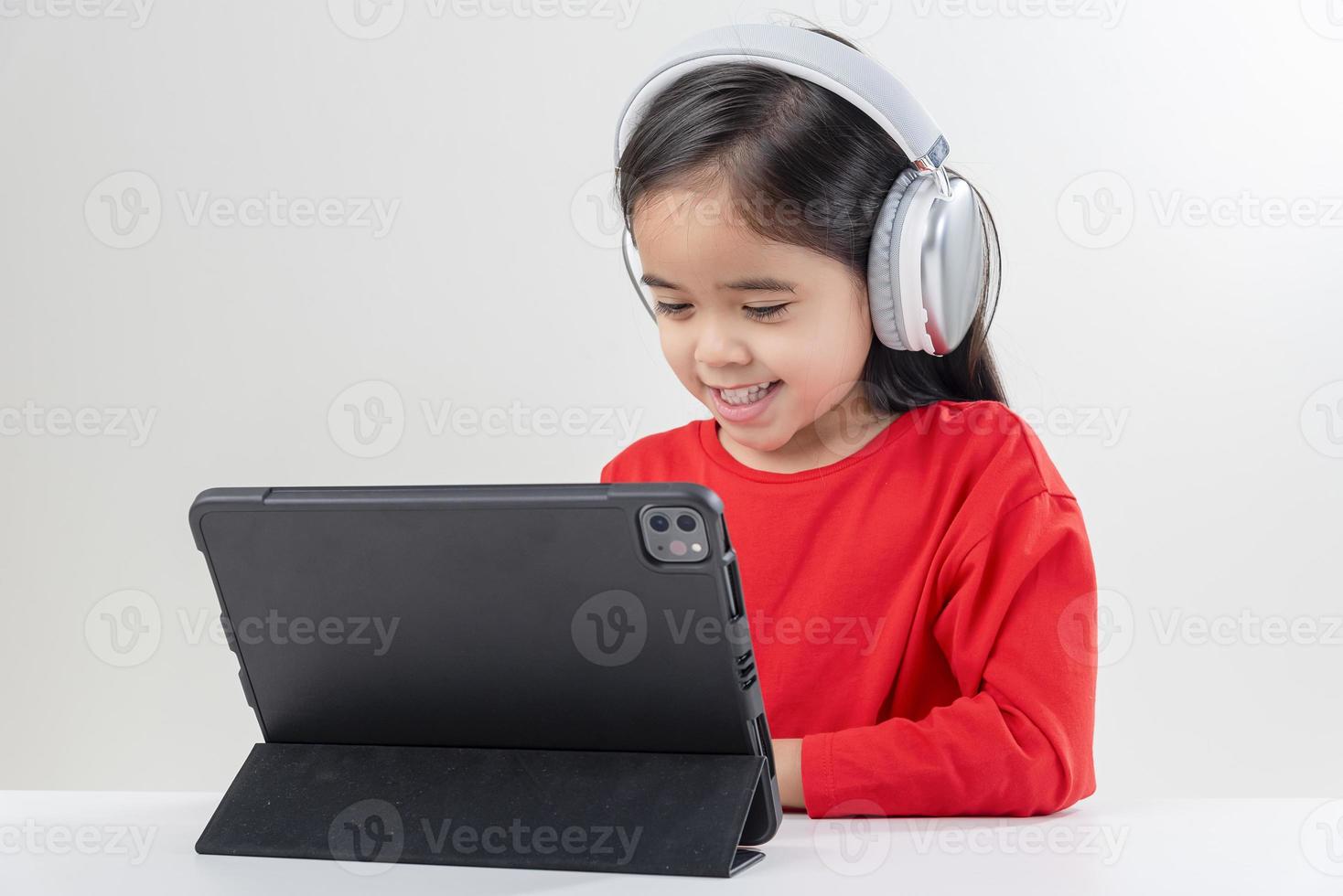 little girl asia cute put on headphones have video call distant class with teacher using laptop,  study online on computer, homeschooling concept photo