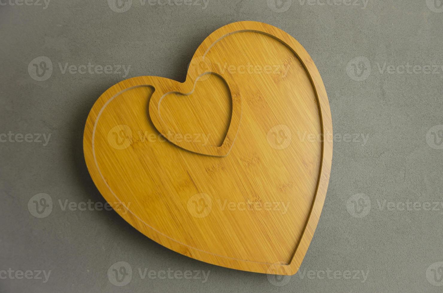 bandeja de madera en forma de corazón sobre un fondo gris foto