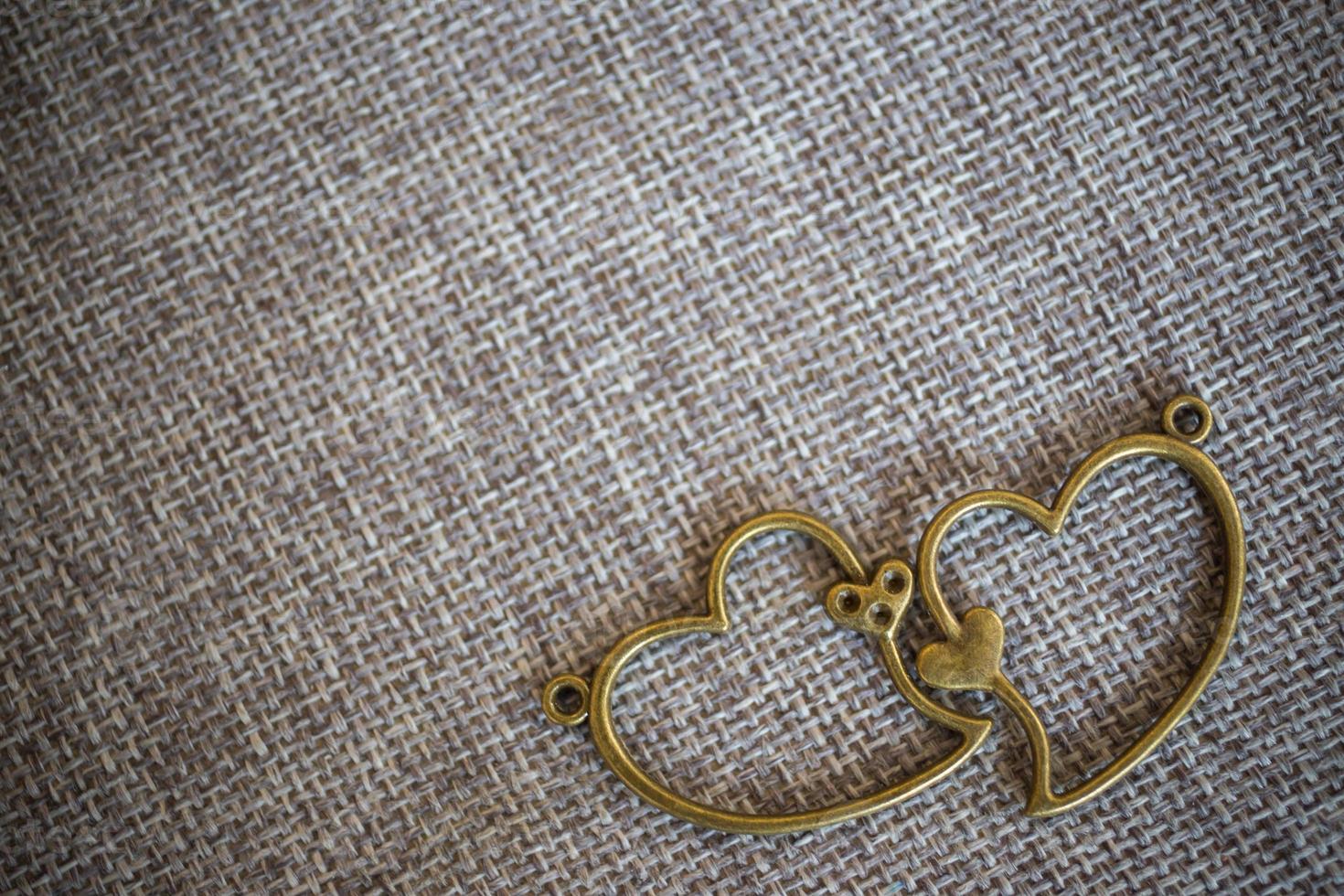 colgante de corazón en tela vieja, fondo de textura, concepto de San Valentín foto