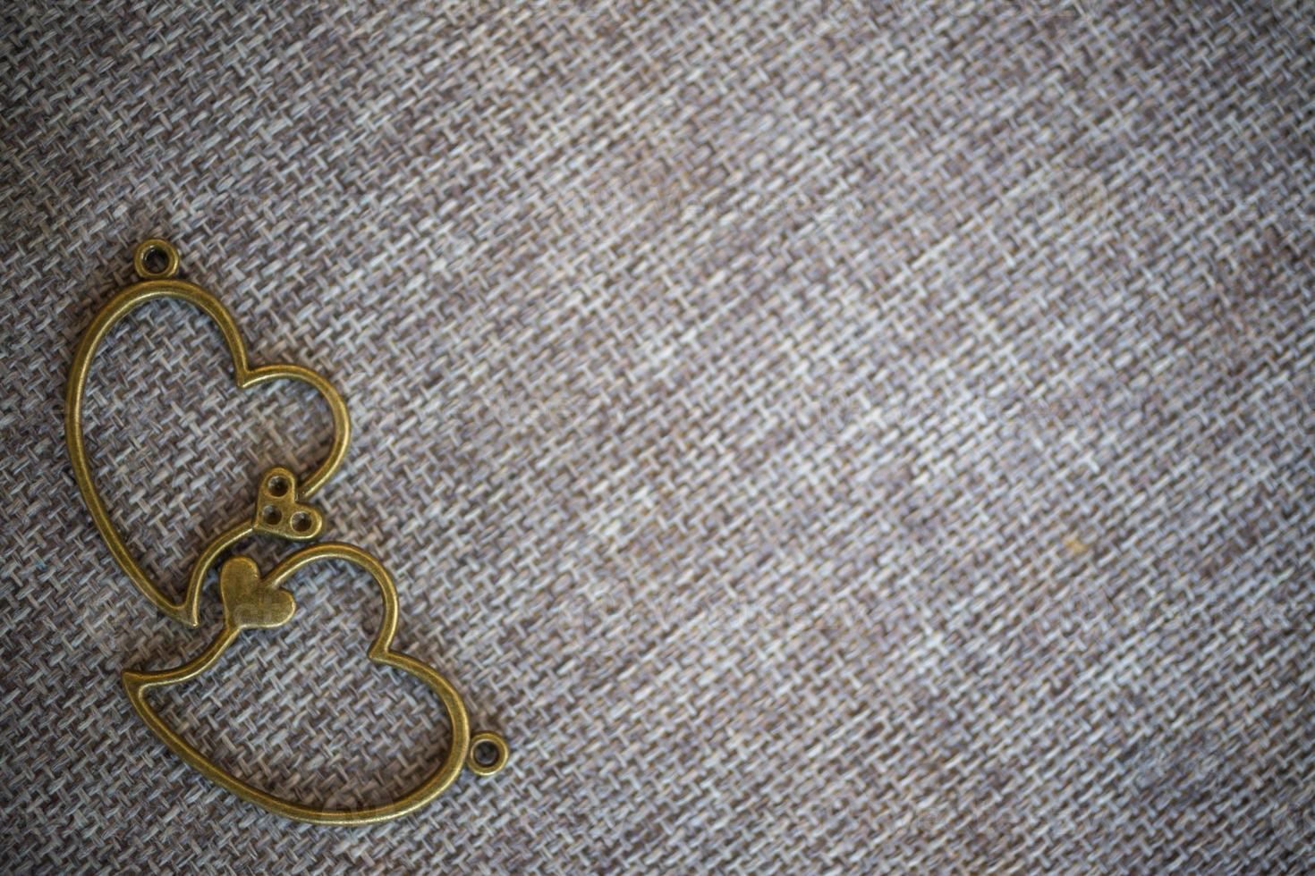 colgante de corazón en tela vieja, fondo de textura, concepto de San Valentín foto