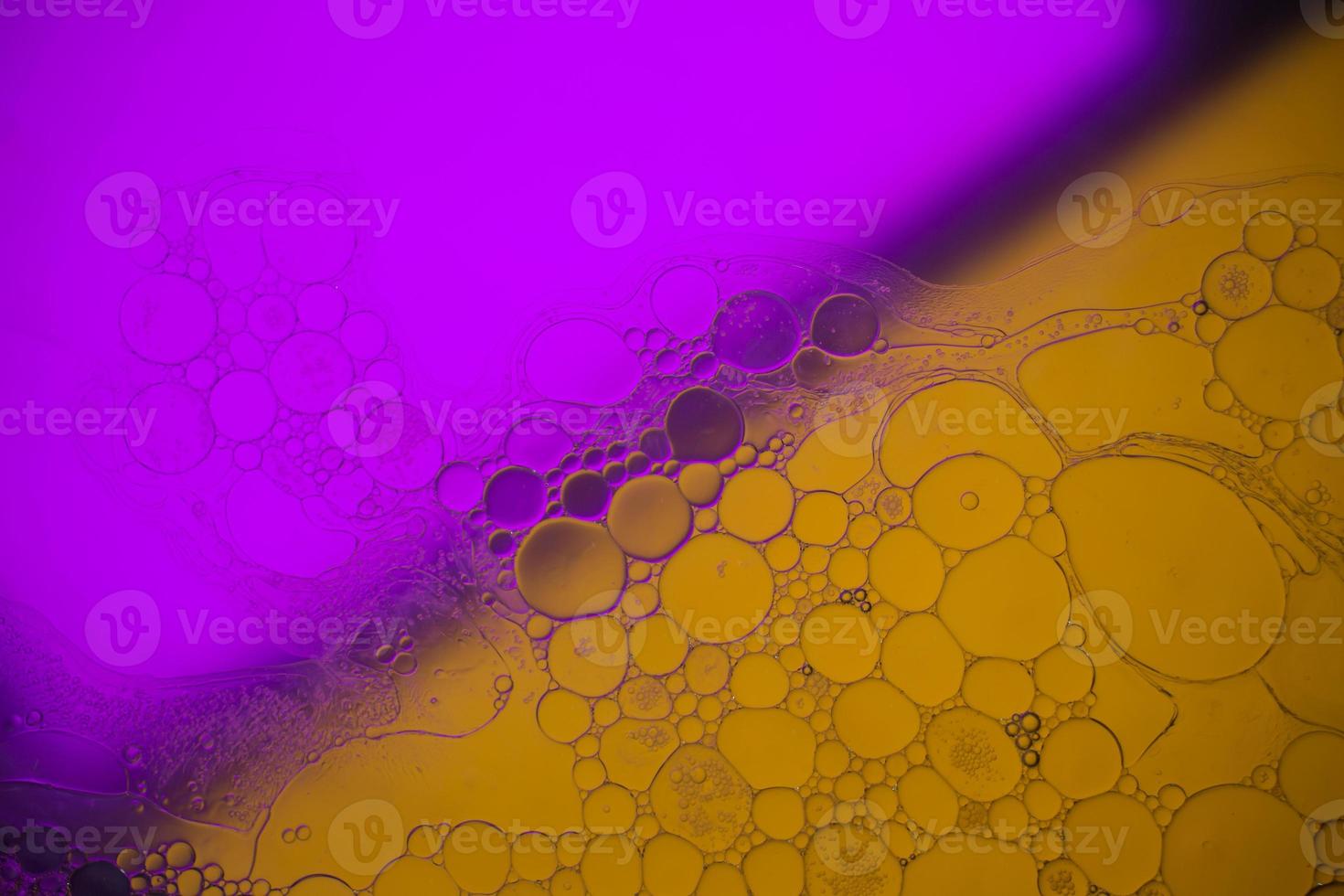 Top view movement of bubbles in the liquid. Oil surface multicolored background. Fantastic structure of colorful bubbles. Colorful artistic image of oil drop floating on the water. photo