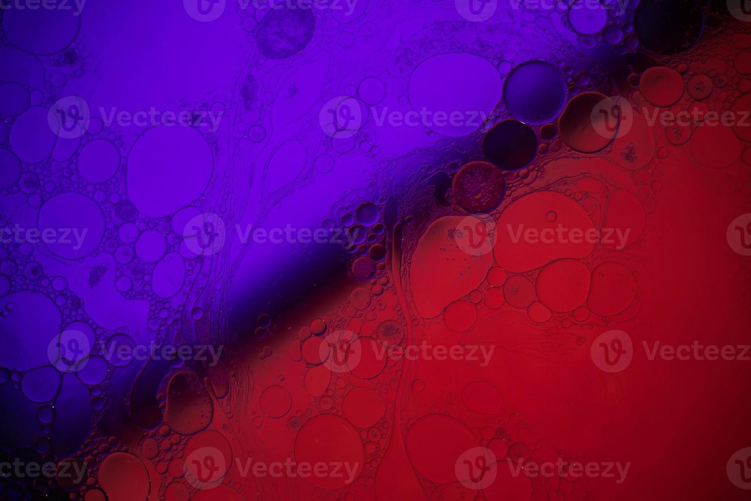 Top view movement of bubbles in the liquid. Oil surface multicolored background. Fantastic structure of colorful bubbles. Colorful artistic image of oil drop floating on the water. photo