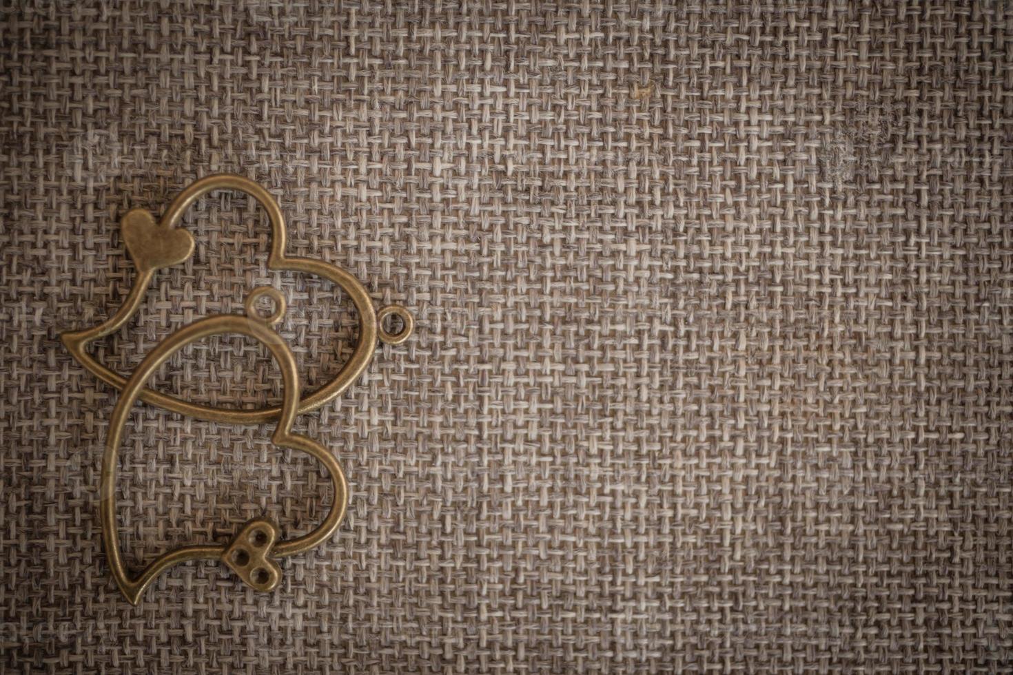 Heart pendant on old fabric, texture background, valentine concept photo