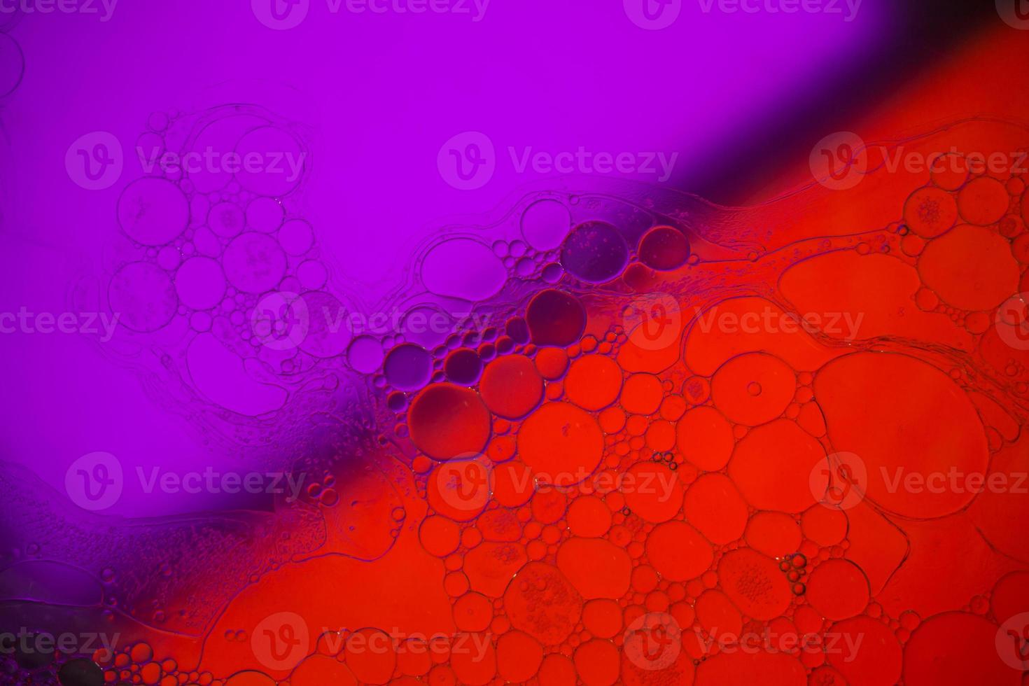 Top view movement of bubbles in the liquid. Oil surface multicolored background. Fantastic structure of colorful bubbles. Colorful artistic image of oil drop floating on the water. photo