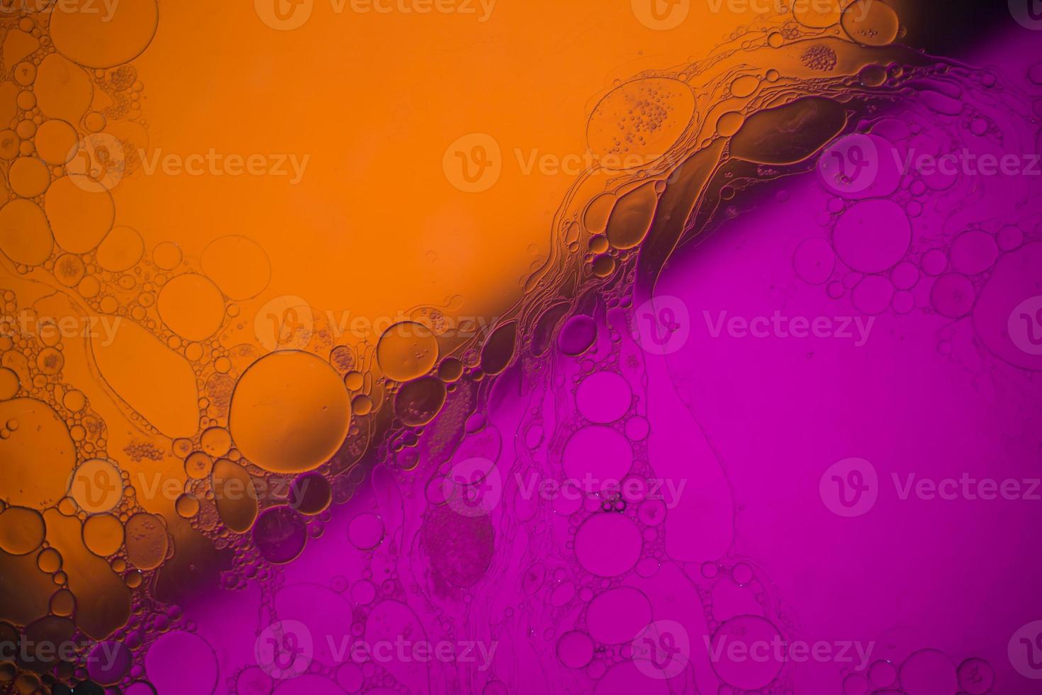 Top view movement of bubbles in the liquid. Oil surface multicolored background. Fantastic structure of colorful bubbles. Colorful artistic image of oil drop floating on the water. photo