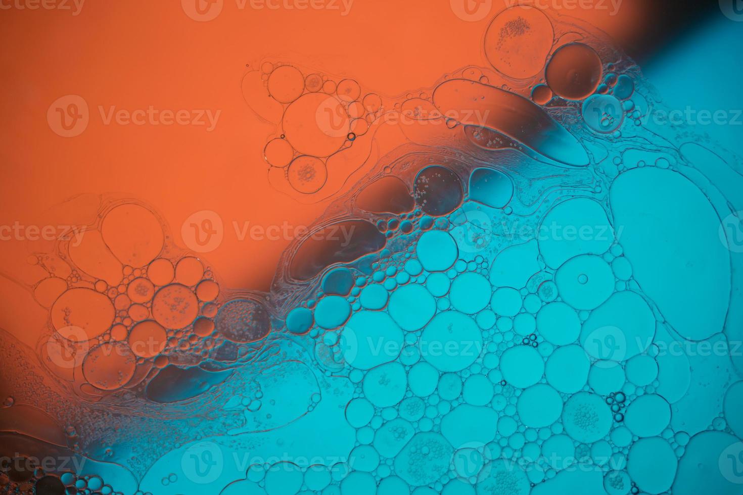 Top view movement of bubbles in the liquid. Oil surface multicolored background. Fantastic structure of colorful bubbles. Colorful artistic image of oil drop floating on the water. photo