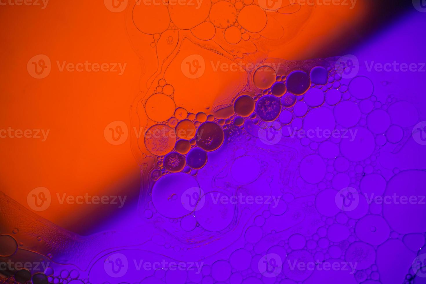 vista superior movimiento de burbujas en el líquido. fondo multicolor de la superficie del aceite. fantástica estructura de burbujas de colores. imagen artística colorida de gota de aceite flotando en el agua. foto