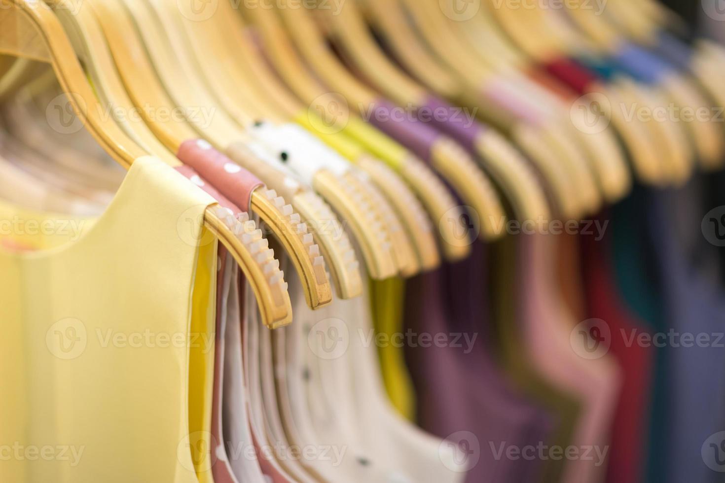 Clothes that are arranged on shelves and hangers photo