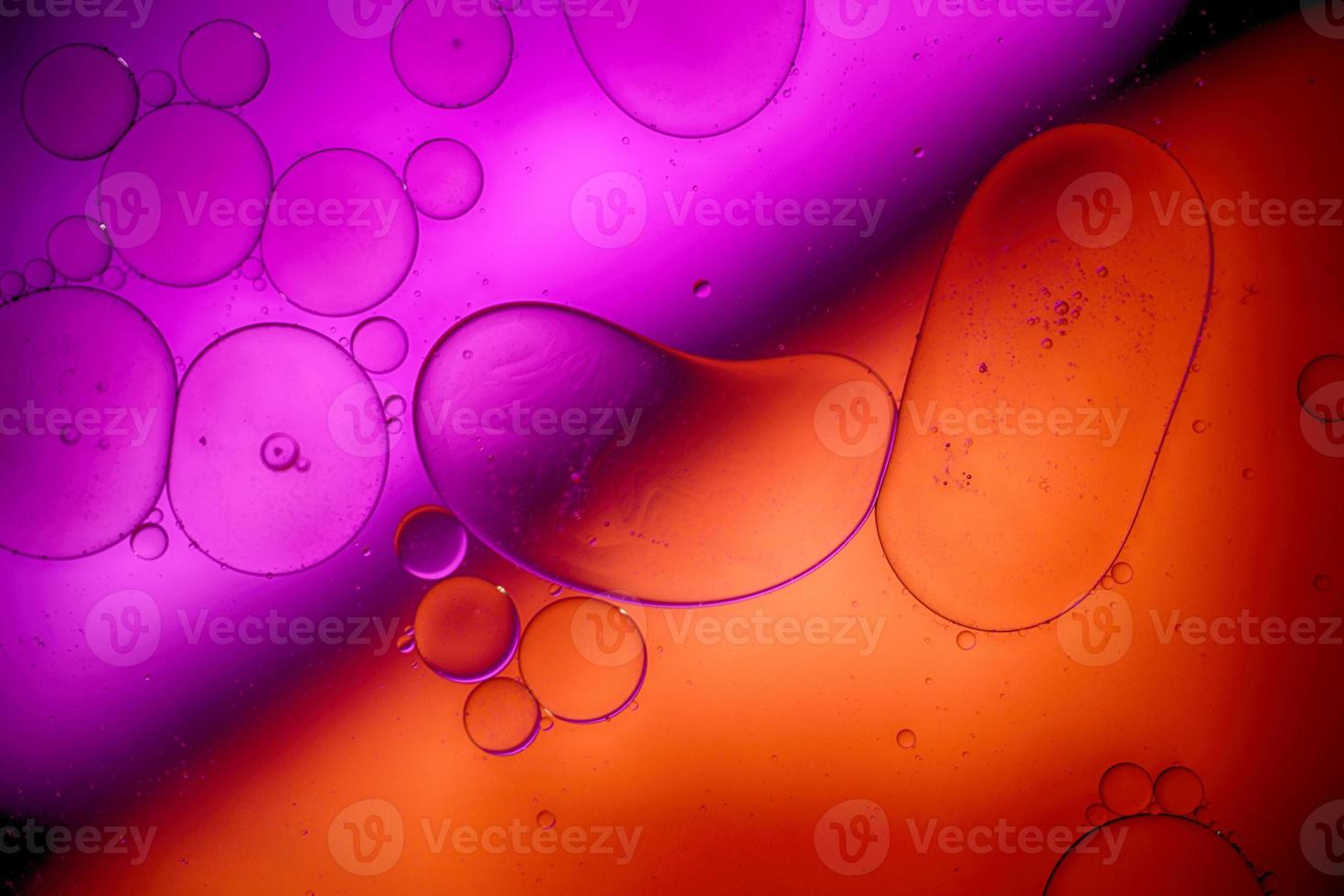 Top view movement of bubbles in the liquid. Oil surface multicolored background. Fantastic structure of colorful bubbles. Colorful artistic image of oil drop floating on the water. photo