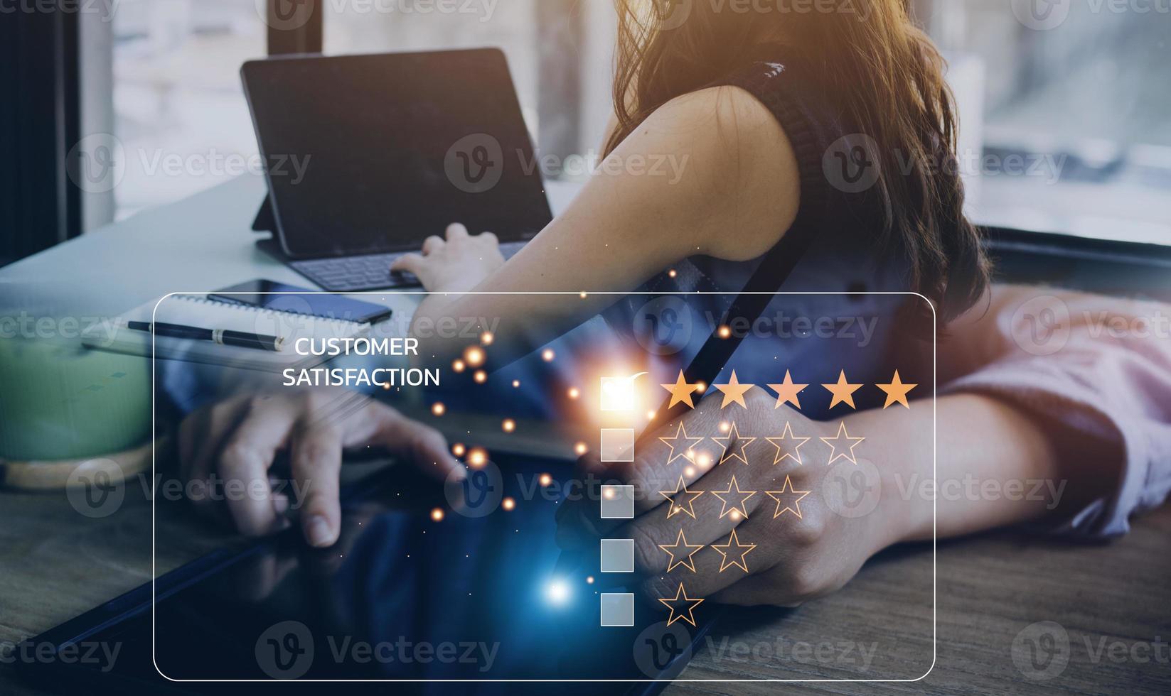 close up Man hand using computer Notebook with popup five star icon for feedback review satisfaction service, Customer service experience and business satisfaction survey. photo