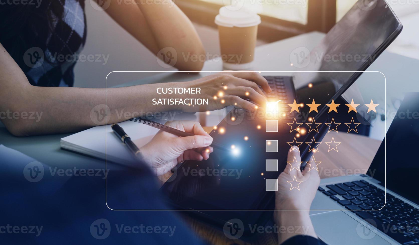 close up Man hand using computer Notebook with popup five star icon for feedback review satisfaction service, Customer service experience and business satisfaction survey. photo