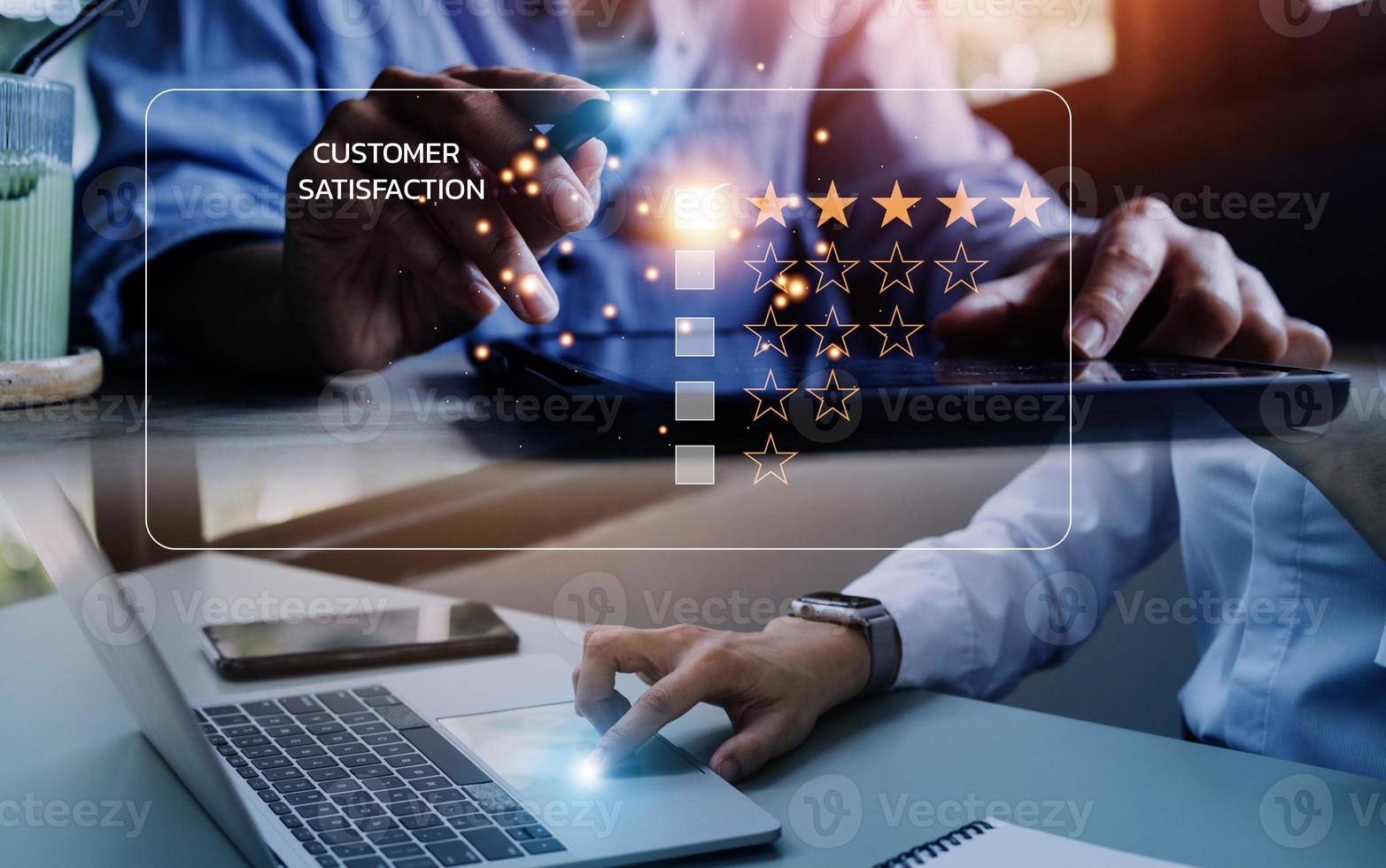 close up Man hand using computer Notebook with popup five star icon for feedback review satisfaction service, Customer service experience and business satisfaction survey. photo