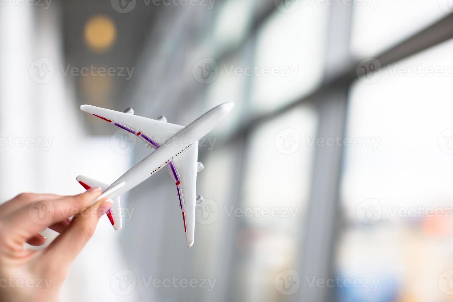 Close up hand holding an airplane model at airport photo