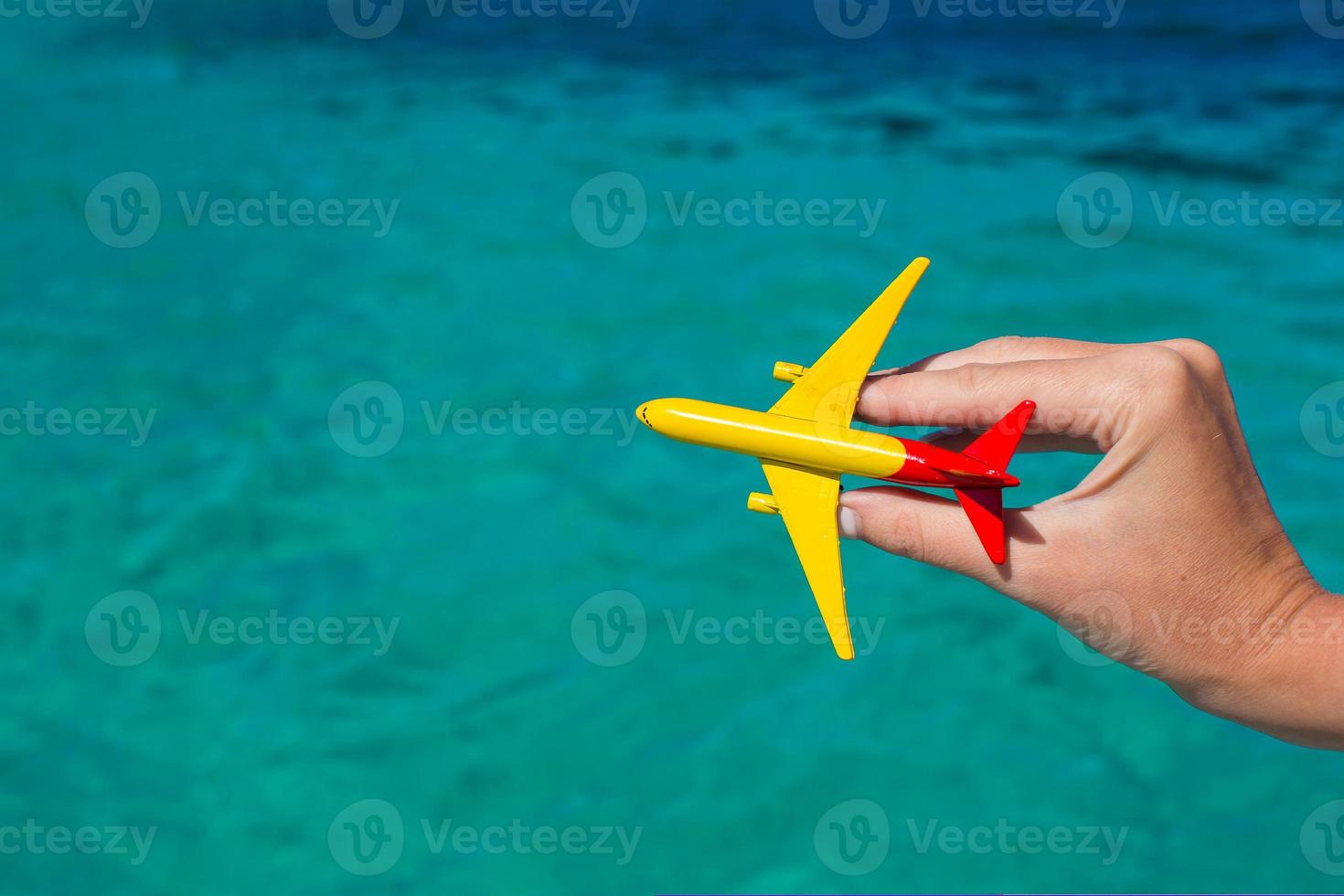 Small homemade plane in hand on background of the sea photo