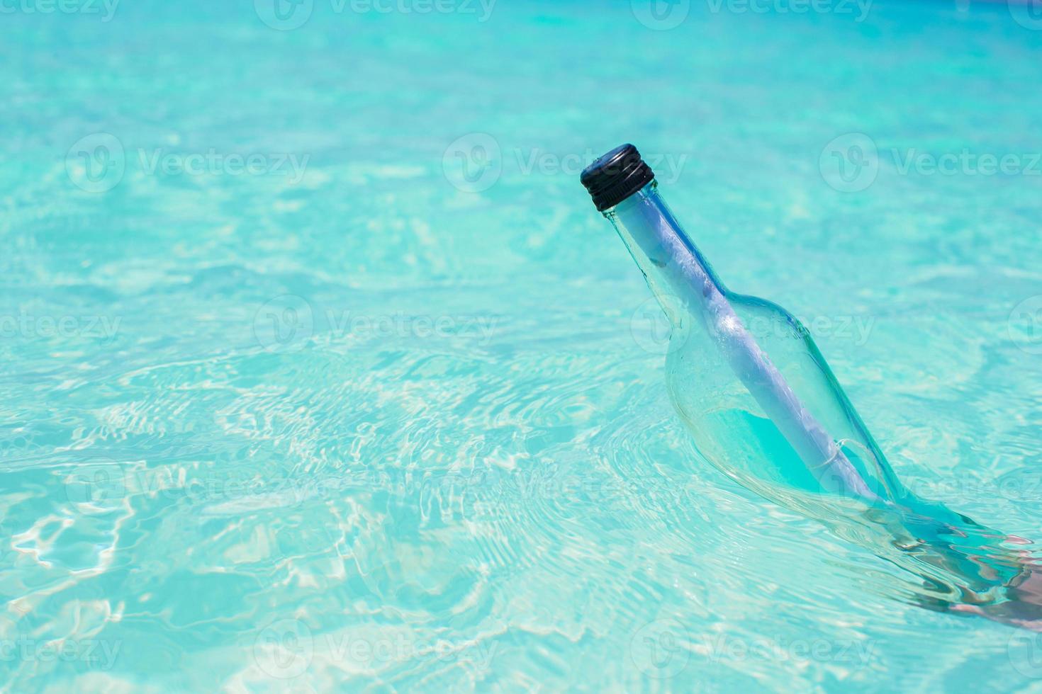 Bottle with a message in the hand background blue sky photo