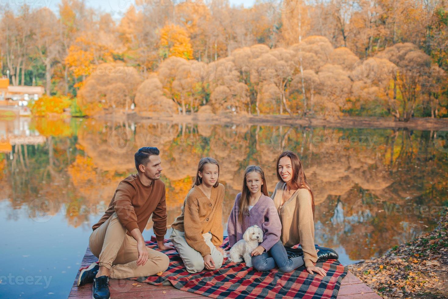 Beautiful family at autumn warm day near lake photo