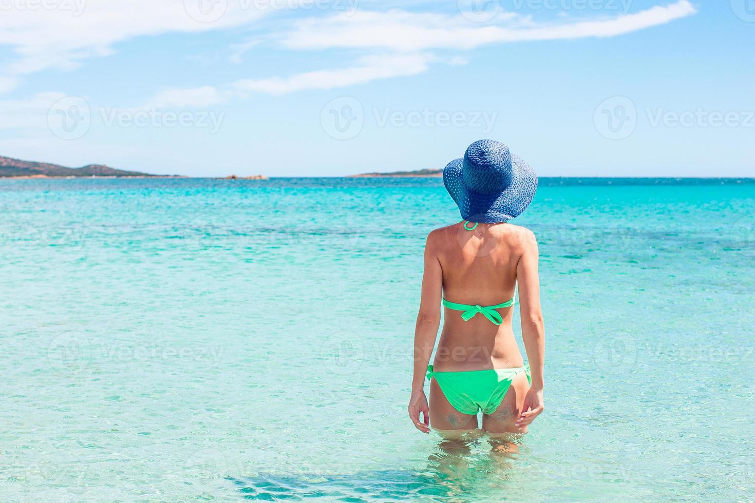 Young woman enjoying the sun sunbathing by perfect turquoise ocean photo