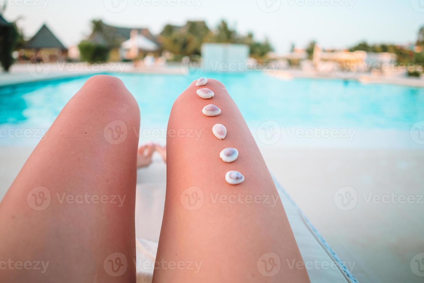 Female feet on white sandy beach background the sea photo
