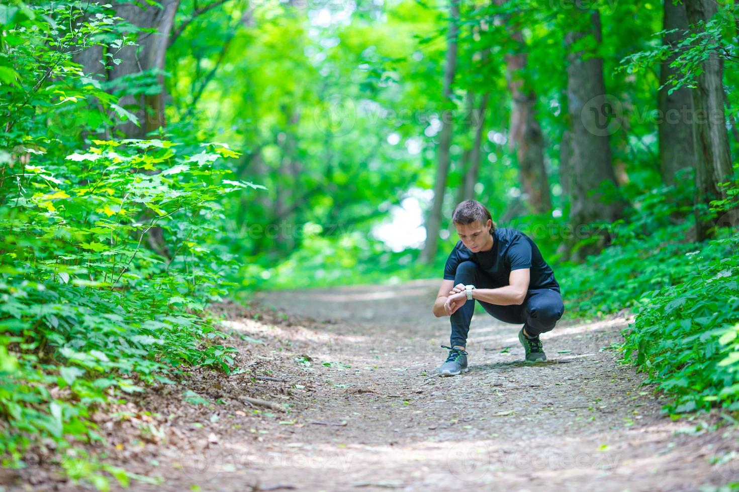 Runner looking at smart watch heart rate monitor having break while running photo